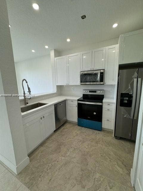 17660 NW 73rd Avenue, #202-3, Hialeah, Hialeah, FL 33015 Kitchen featuring white shaker-style cabinetry, stainless steel appliances, solid surface countertops, a deep undermount sink with a gooseneck faucet, and large-format tile flooring
