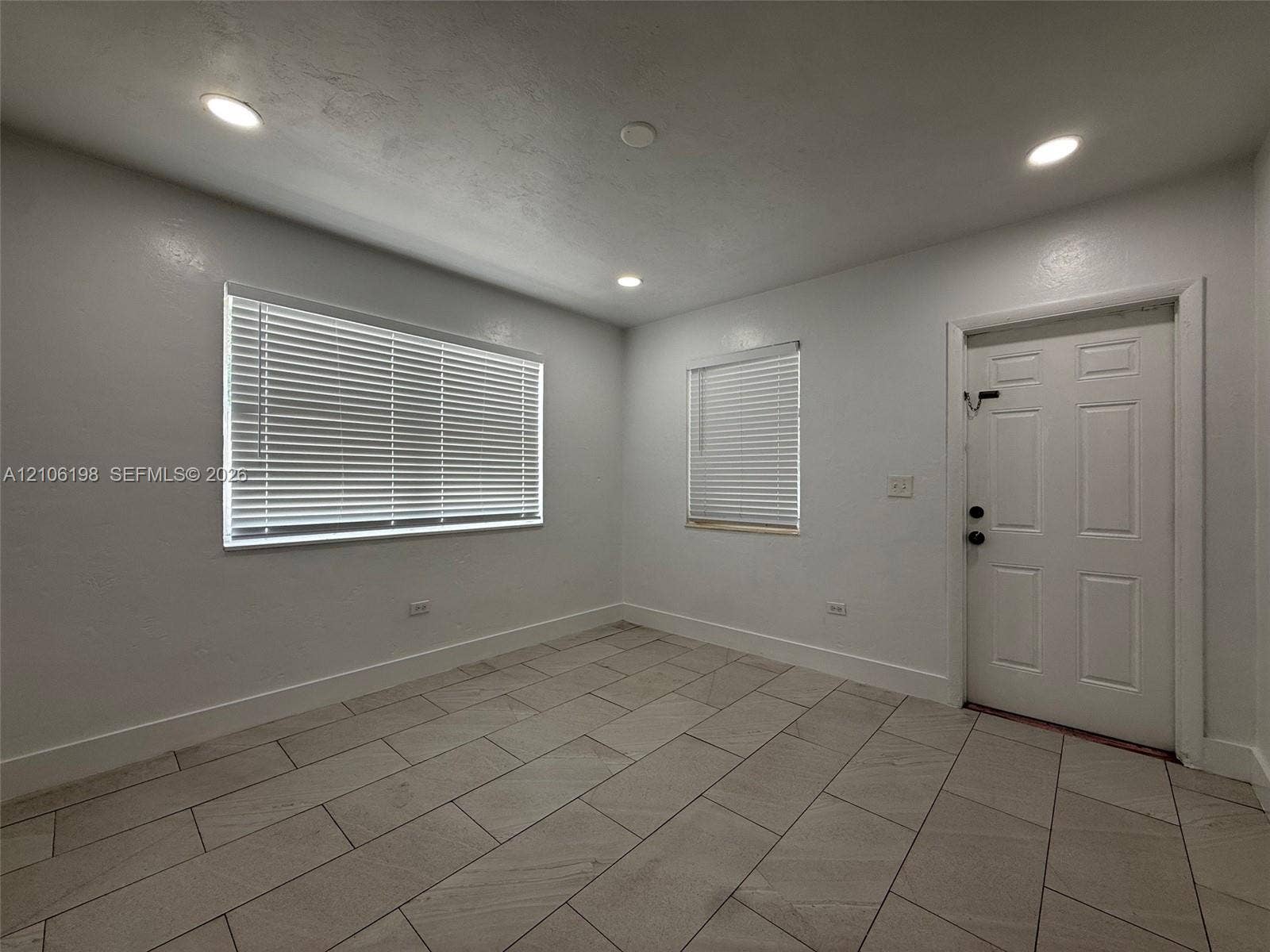 600 NW 116th Terrace, Miami, FL 33168 Neutral-toned ceramic tile flooring, recessed lighting, and white six-panel exterior door