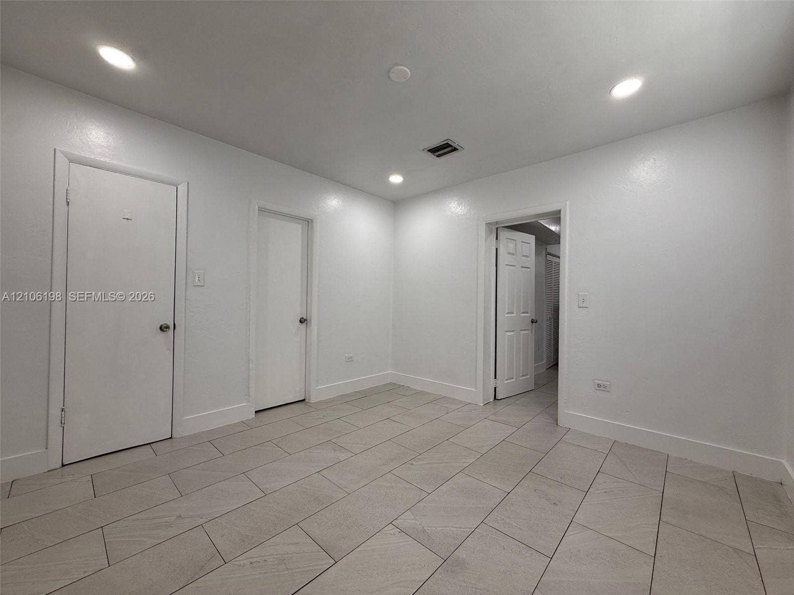 600 NW 116th Terrace, Miami, FL 33168 Interior space featuring recessed lighting, smooth-finish walls, and neutral-toned rectangular tile flooring