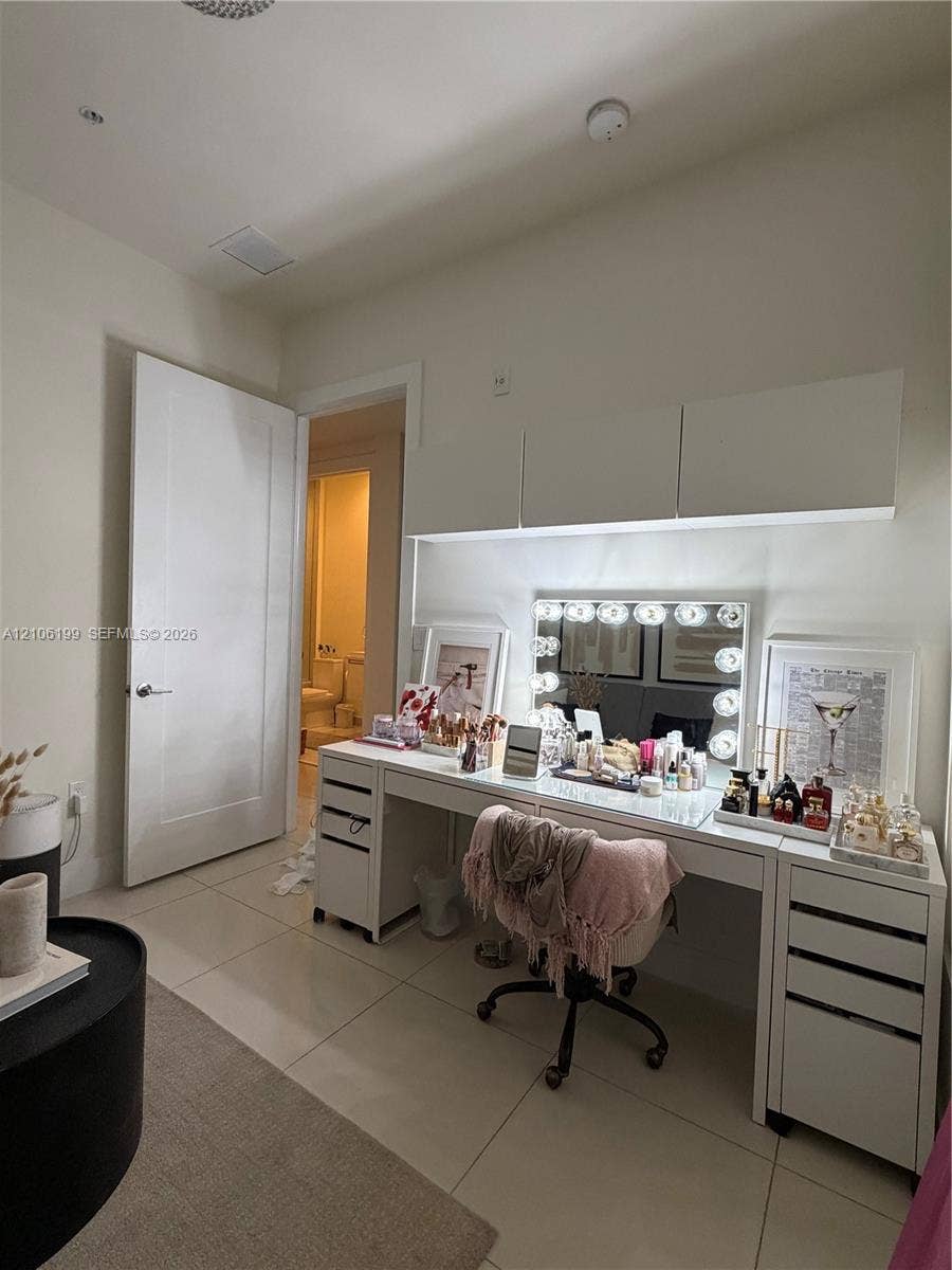 Built-in white overhead cabinetry and neutral tile flooring