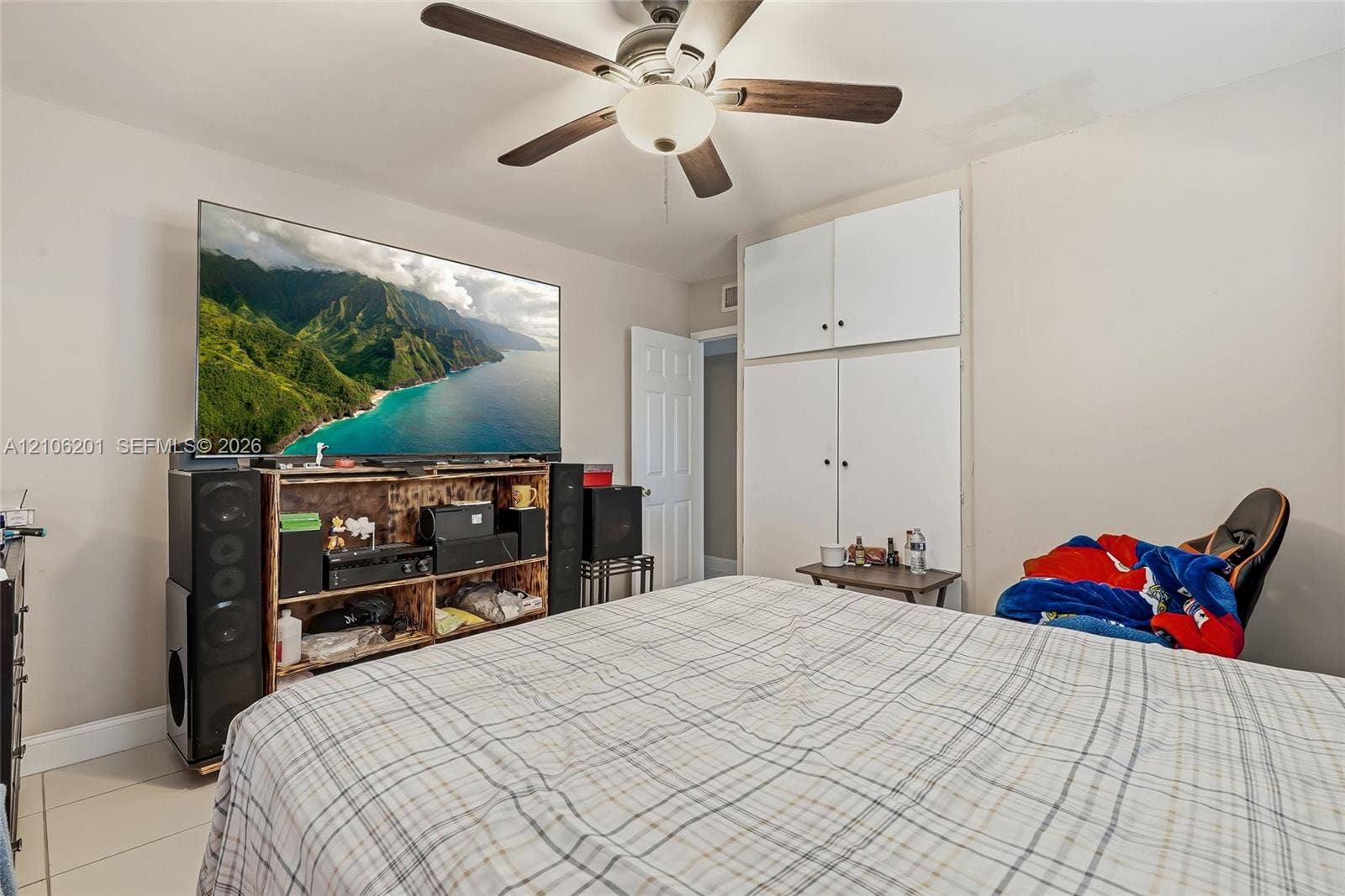 Room featuring a ceiling fan with integrated lighting and built-in floor-to-ceiling cabinetry with overhead storage
