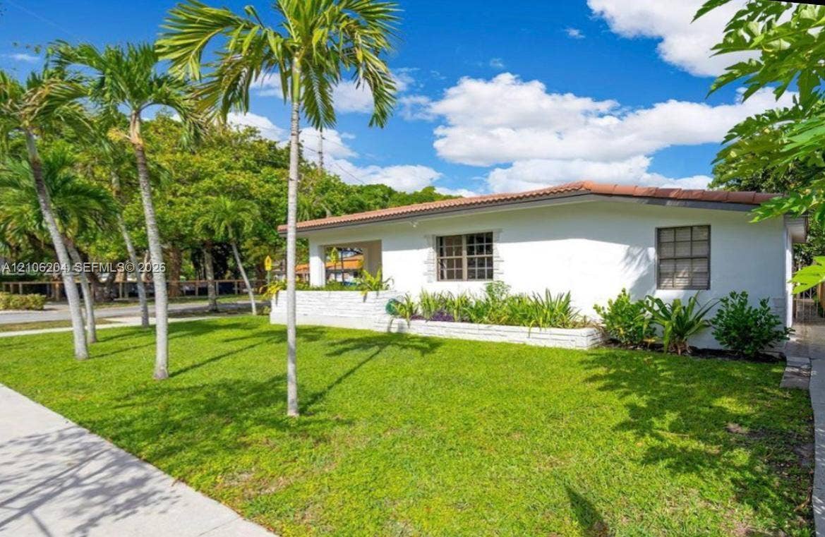 2121 SW 13th Avenue, #Studio, Miami, Miami, FL 33145 Single-story residence featuring a painted masonry exterior, a low-pitch hip roof with clay tiles, a covered entryway, and a raised brick planter bed