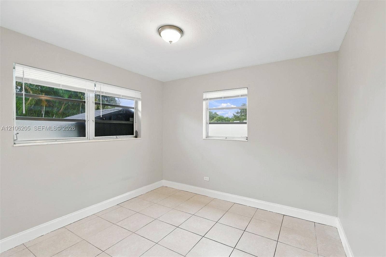 6941 SW 5th Street, Pembroke Pines, Pembroke Pines, FL 33023 Neutral-toned interior featuring large windows with horizontal blinds, overhead flush-mount lighting, and light-colored tile flooring