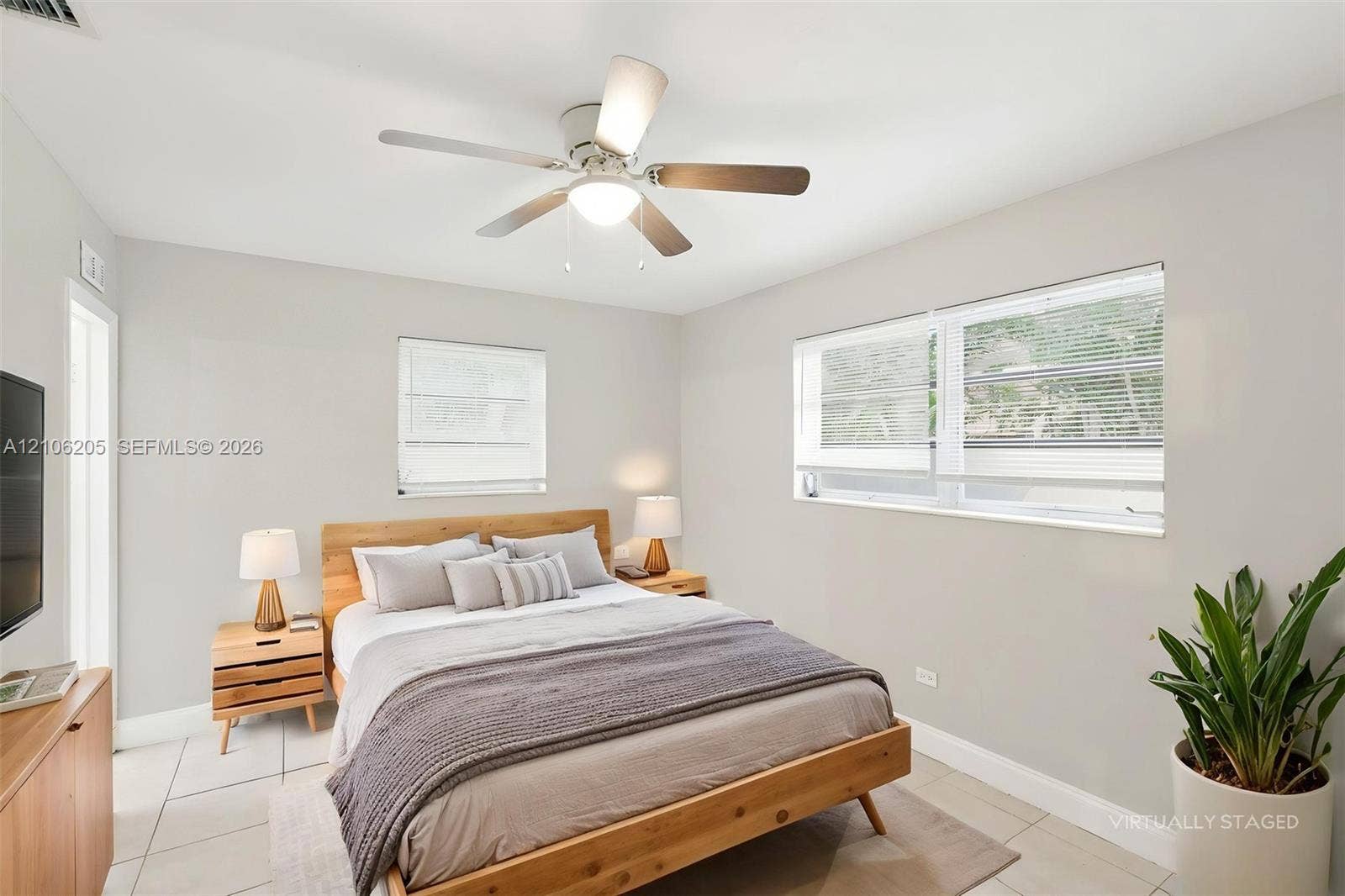 6941 SW 5th Street, Pembroke Pines, Pembroke Pines, FL 33023 Neutral-toned interior featuring large-format tile flooring, a multi-blade ceiling fan with integrated lighting, and dual windows