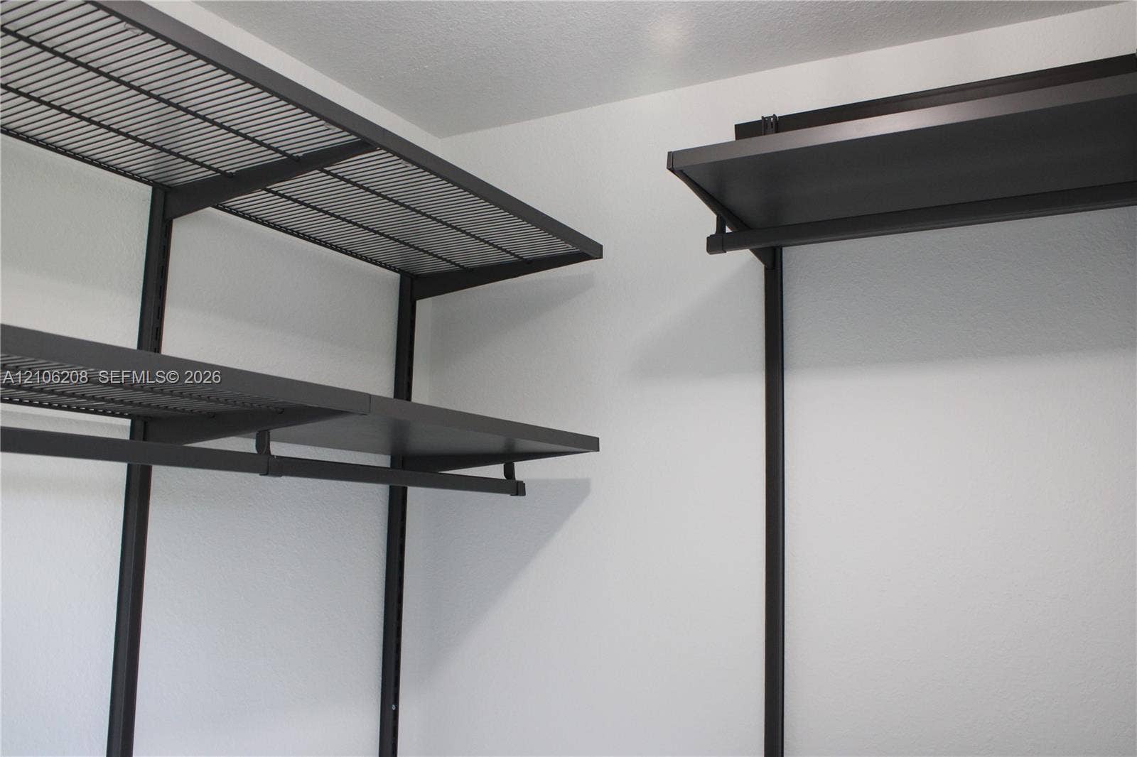 Customizable dark-finish metal shelving system featuring tiered wire racking and integrated hanging rods