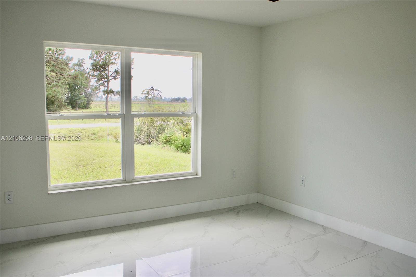 Neutral-toned interior featuring large-format tile flooring and a double-pane window