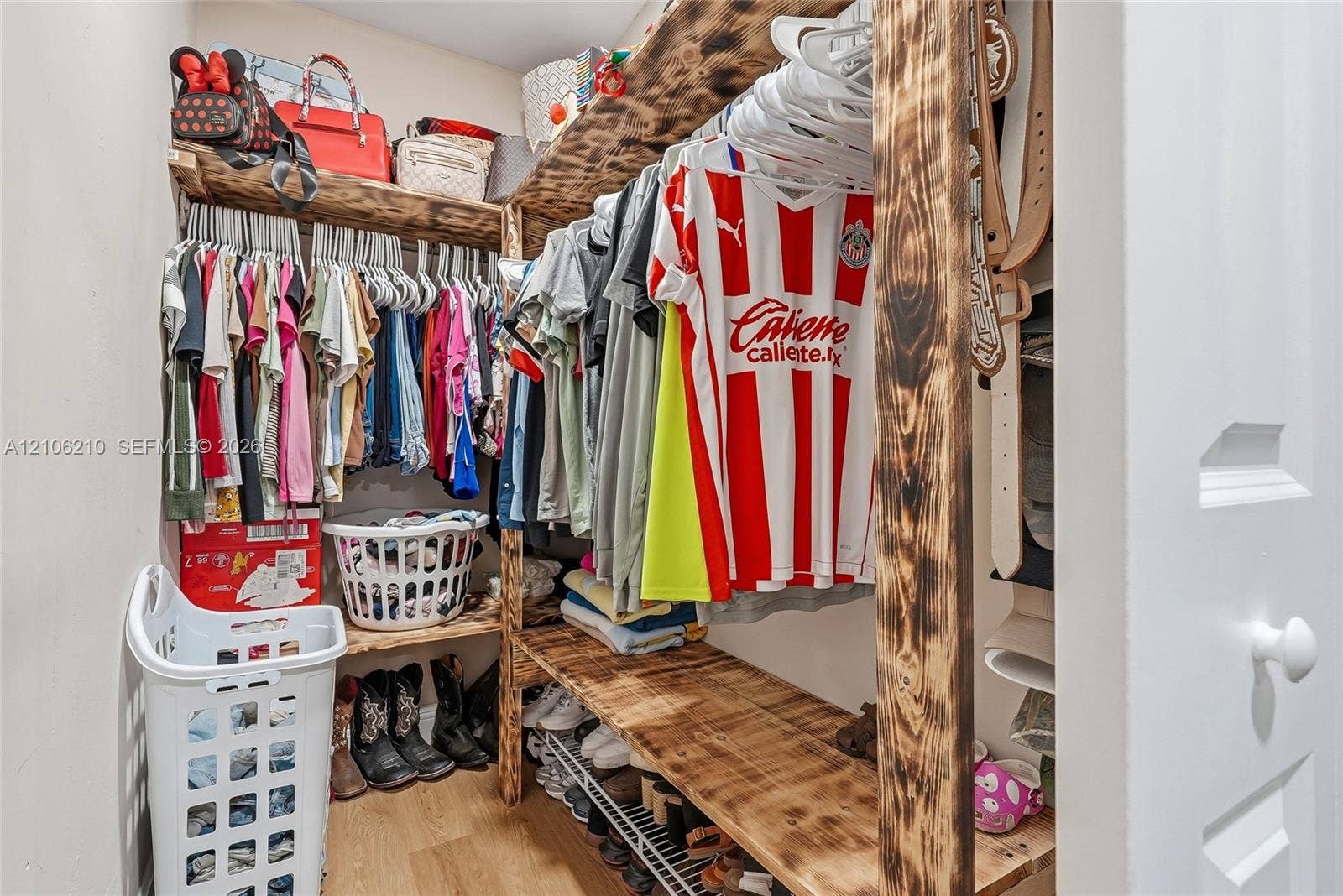 1111 S 7th Street, Fort Pierce, FL 34950 Custom walk-in closet featuring multi-level natural wood shelving and integrated rod storage