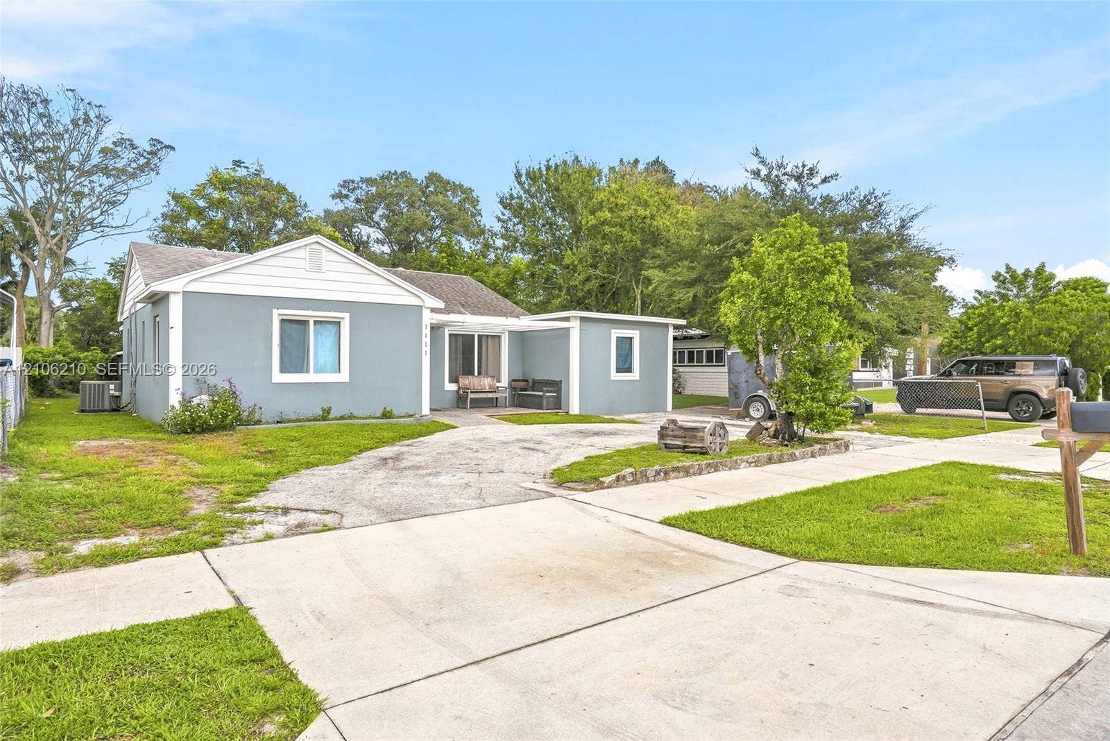 1111 S 7th Street, Fort Pierce, FL 34950 Single-story residence featuring light blue exterior siding, white trim, a covered front entryway, and a concrete driveway