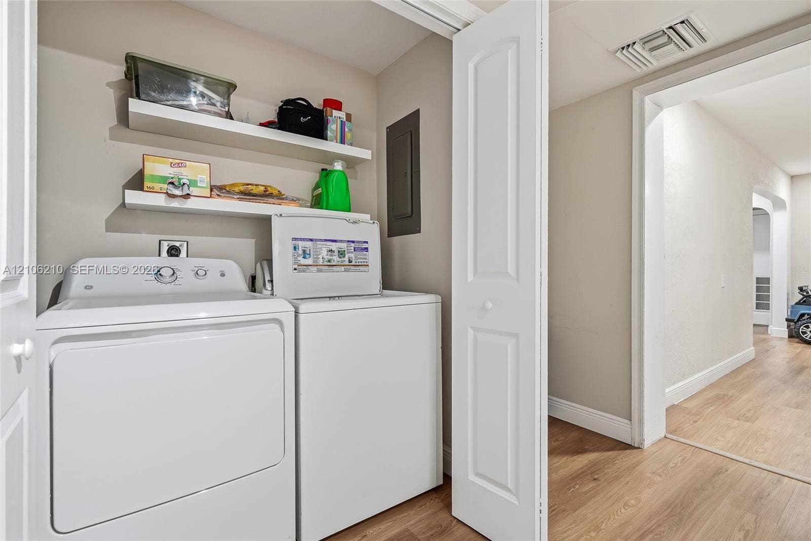 1111 S 7th Street, Fort Pierce, FL 34950 Laundry area featuring two white built-in shelves and a bi-fold door