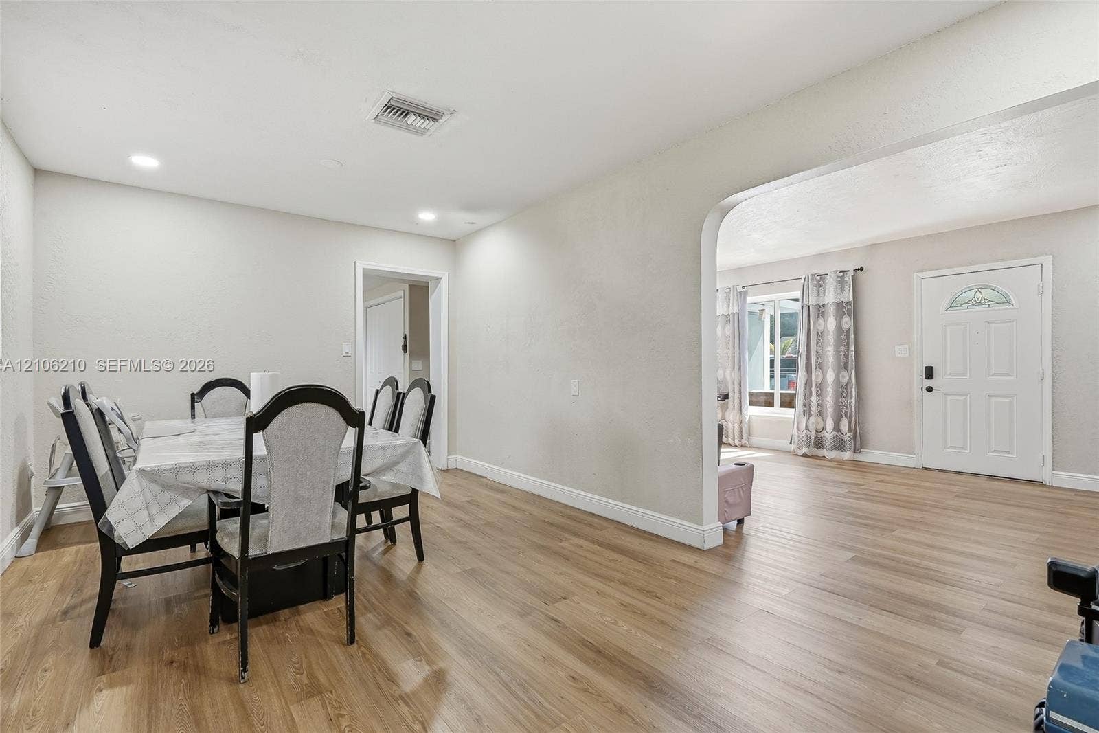 1111 S 7th Street, Fort Pierce, FL 34950 Open-concept interior featuring wood-finish flooring, recessed lighting, and a prominent arched entryway leading to the exterior entrance door