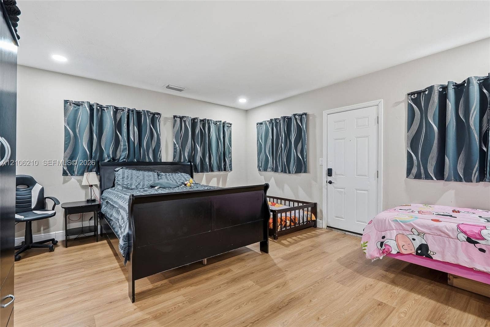 1111 S 7th Street, Fort Pierce, FL 34950 Neutral-toned interior featuring wood-finish flooring, recessed lighting, and a solid-panel door with electronic keypad entry