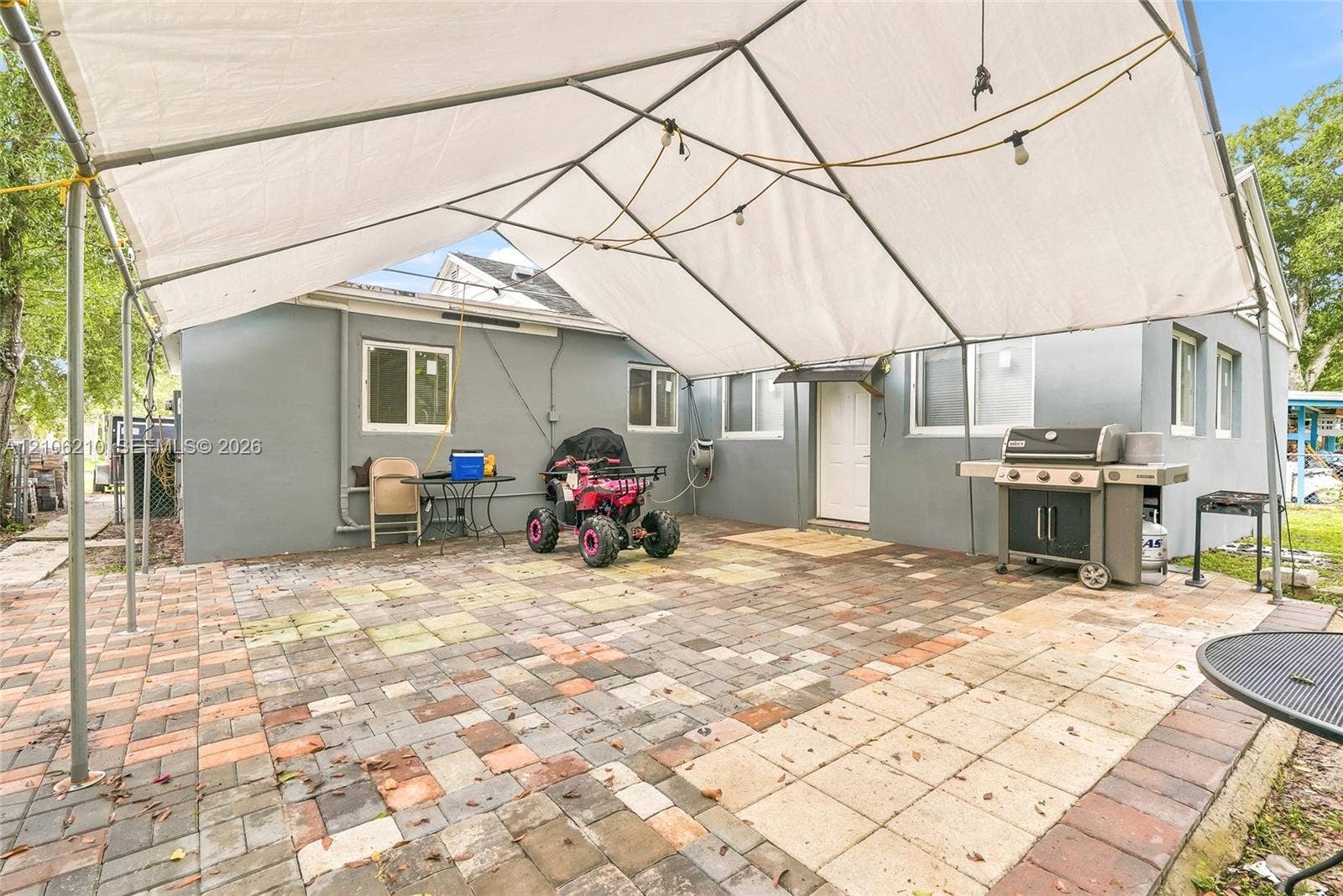 1111 S 7th Street, Fort Pierce, FL 34950 Exterior patio featuring multi-tonal paver hardscaping and a metal-frame canopy structure