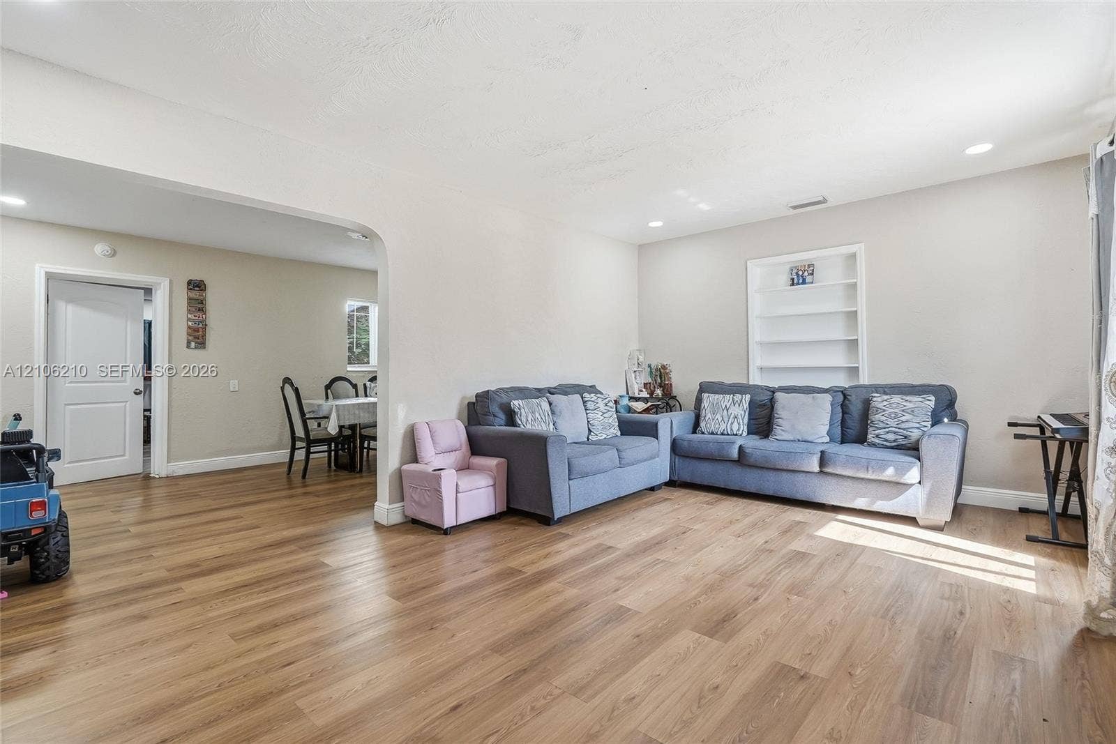 1111 S 7th Street, Fort Pierce, FL 34950 Open-concept interior featuring wood-finish flooring, recessed lighting, and a built-in recessed wall shelving unit