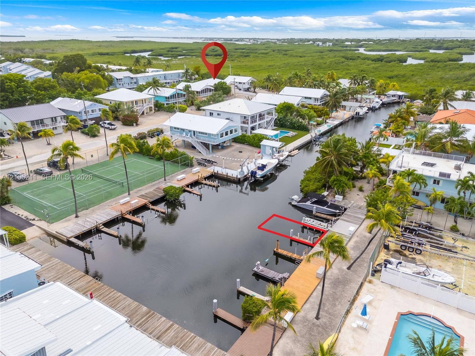 Waterfront property featuring a private boat slip, direct canal access, and mature palm trees