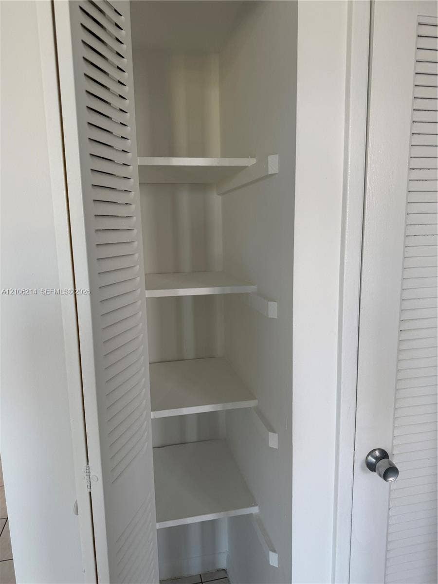 2841 NE 163rd Street, #305, North Miami Beach, North Miami Beach, FL 33160 Storage closet featuring white louvered doors and four fixed interior shelves