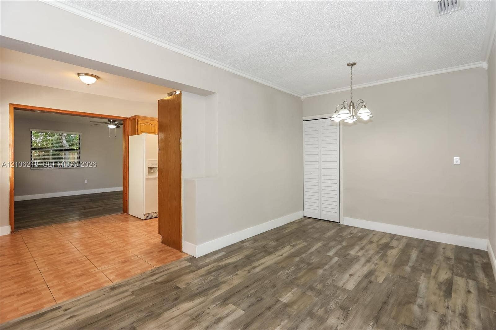 Interior area featuring wood-finish flooring, a multi-arm pendant light fixture, and floor-to-ceiling closet doors