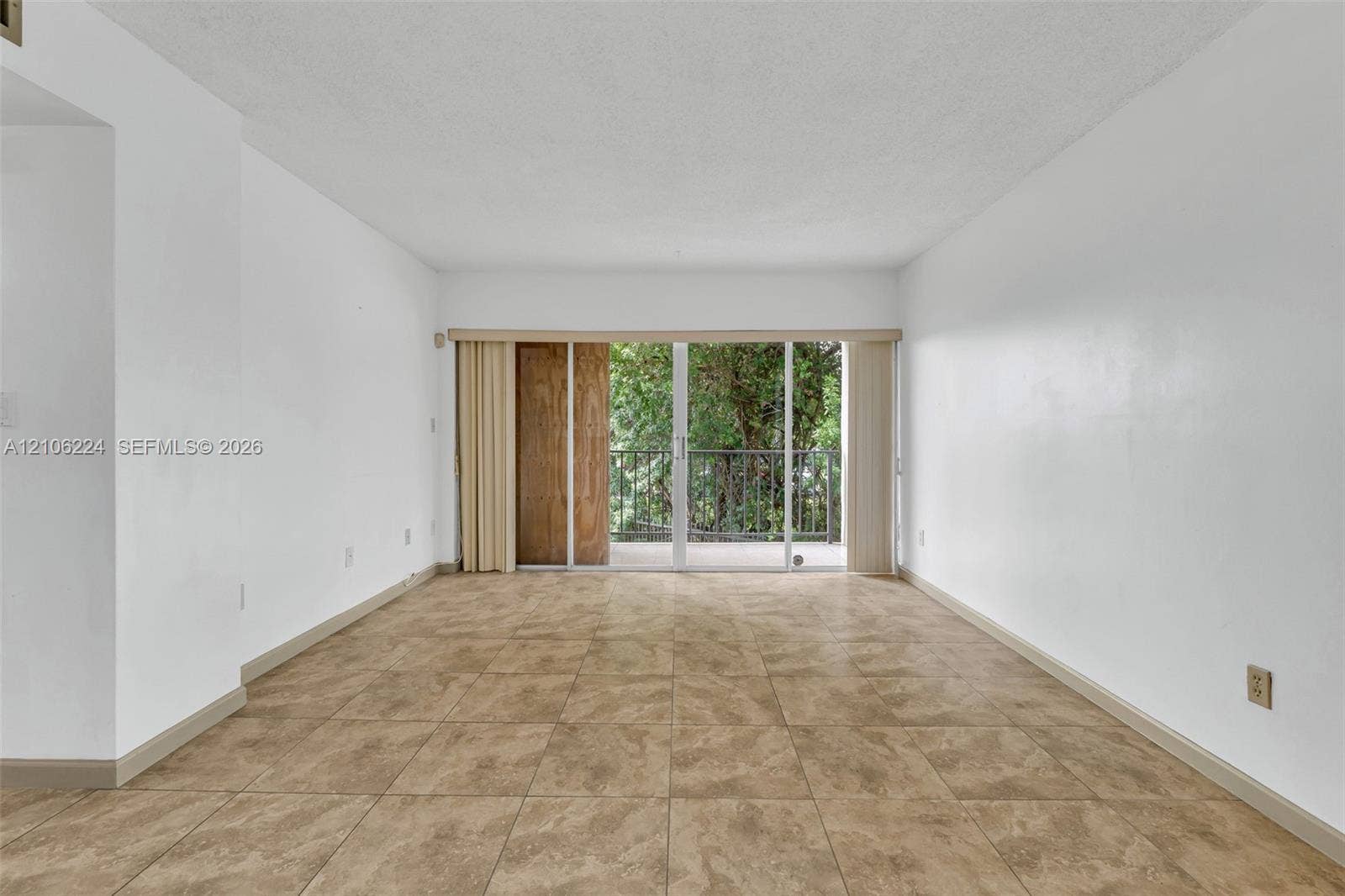 8887 Fontainebleau Boulevard, #206, Miami, Miami, FL 33172 Interior space featuring large-format ceramic tile flooring, neutral wall finishes, and floor-to-ceiling glass sliding doors opening to an exterior balcony