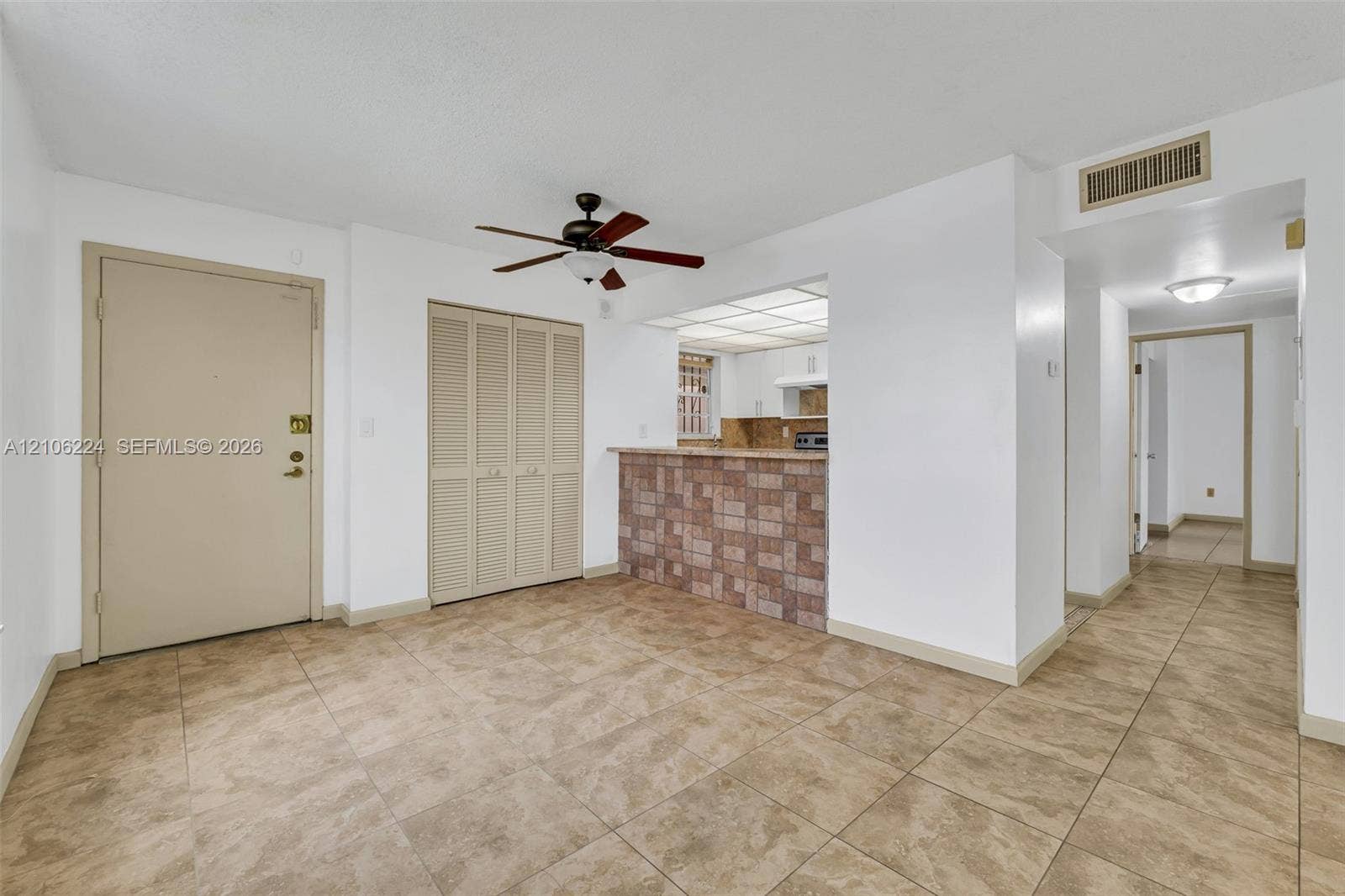 8887 Fontainebleau Boulevard, #206, Miami, Miami, FL 33172 Open floor plan featuring tile flooring, a stone-tiled breakfast bar, built-in louvered-door closet, and ceiling fan
