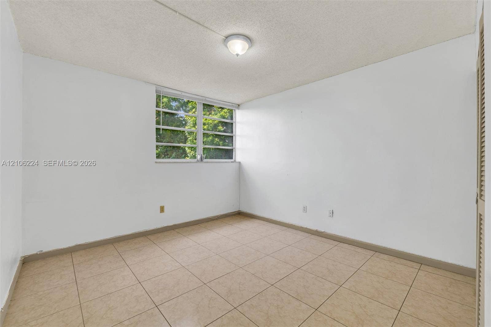 8887 Fontainebleau Boulevard, #206, Miami, Miami, FL 33172 Neutral-toned tiled flooring, textured ceiling with flush-mount lighting, multi-pane window, and louvered closet doors