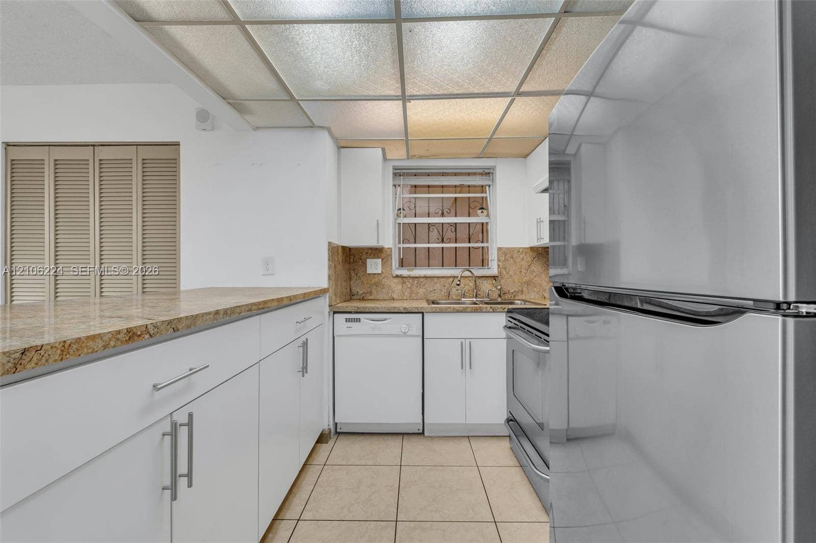 8887 Fontainebleau Boulevard, #206, Miami, Miami, FL 33172 Kitchen featuring white cabinetry, stone-finish countertops, stainless steel appliances, ceramic tile flooring, and a drop ceiling
