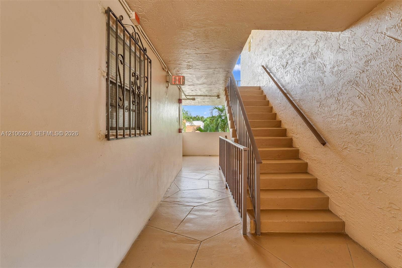 8887 Fontainebleau Boulevard, #206, Miami, Miami, FL 33172 Exterior staircase featuring concrete steps, metal handrailing, stone-patterned tile flooring, and a decorative metal window grate