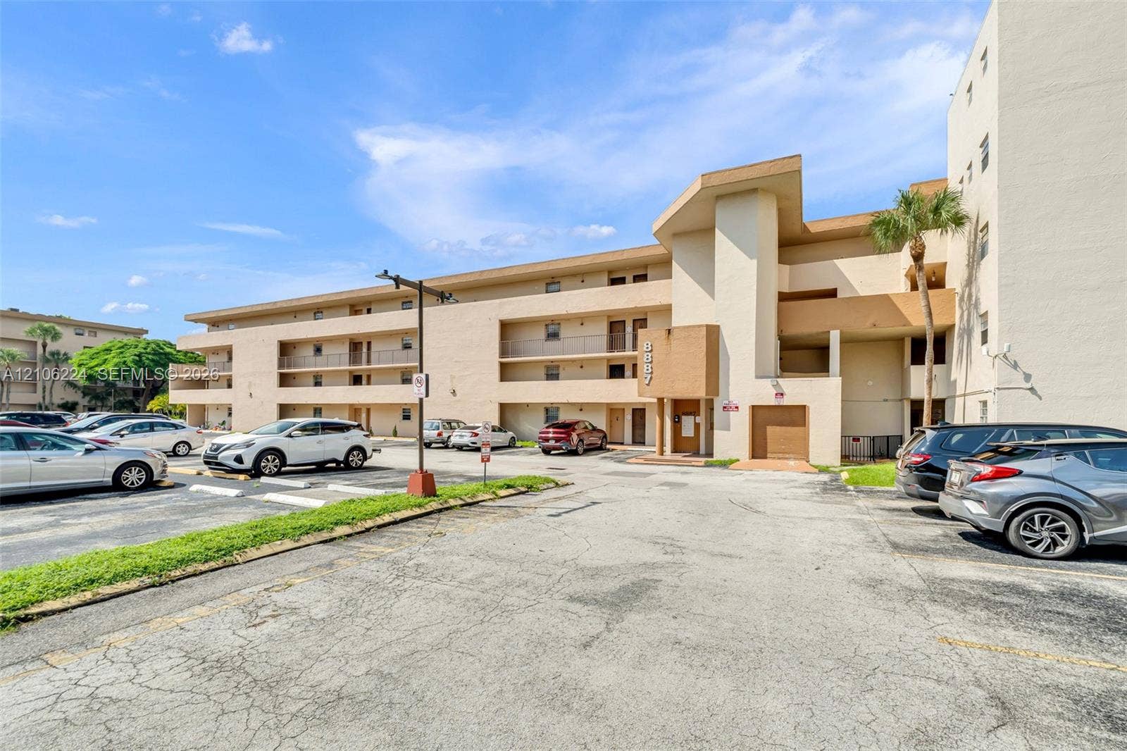 8887 Fontainebleau Boulevard, #206, Miami, Miami, FL 33172 Multi-story residential building exterior featuring stucco cladding, recessed private balconies, ground-level parking, and architectural roofline accents