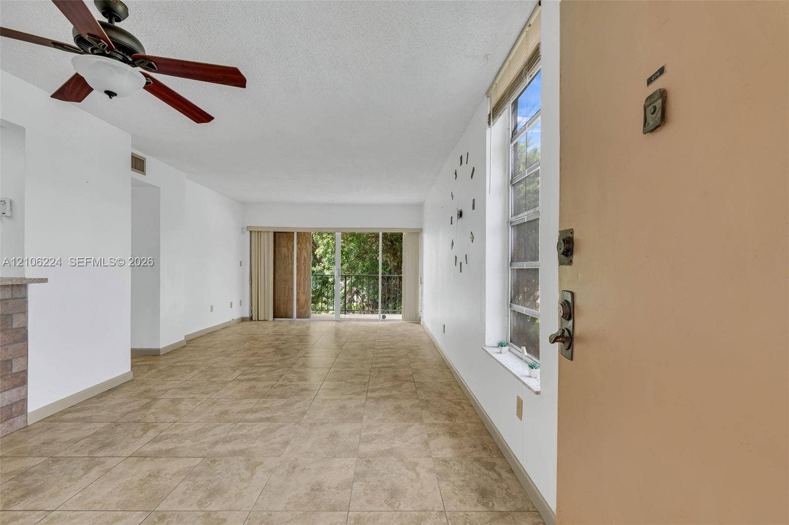 8887 Fontainebleau Boulevard, #206, Miami, Miami, FL 33172 Interior space featuring ceramic tile flooring, a multi-blade ceiling fan, vertical window blinds, and sliding glass doors with exterior access