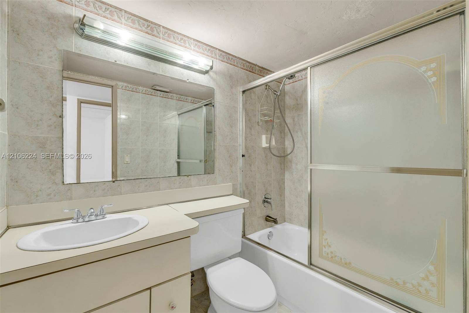 8887 Fontainebleau Boulevard, #206, Miami, Miami, FL 33172 Bathroom featuring a built-in vanity with a stone-surface countertop, an oval drop-in sink, a wall-mounted full-width mirror with overhead light fixture, and a shower-tub combination enclosed by sliding frosted glass doors
