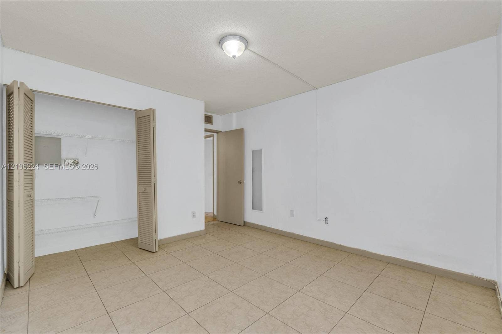 8887 Fontainebleau Boulevard, #206, Miami, Miami, FL 33172 Neutral-toned tile flooring, closet with bi-fold louvered doors, and ceiling-mounted light fixture