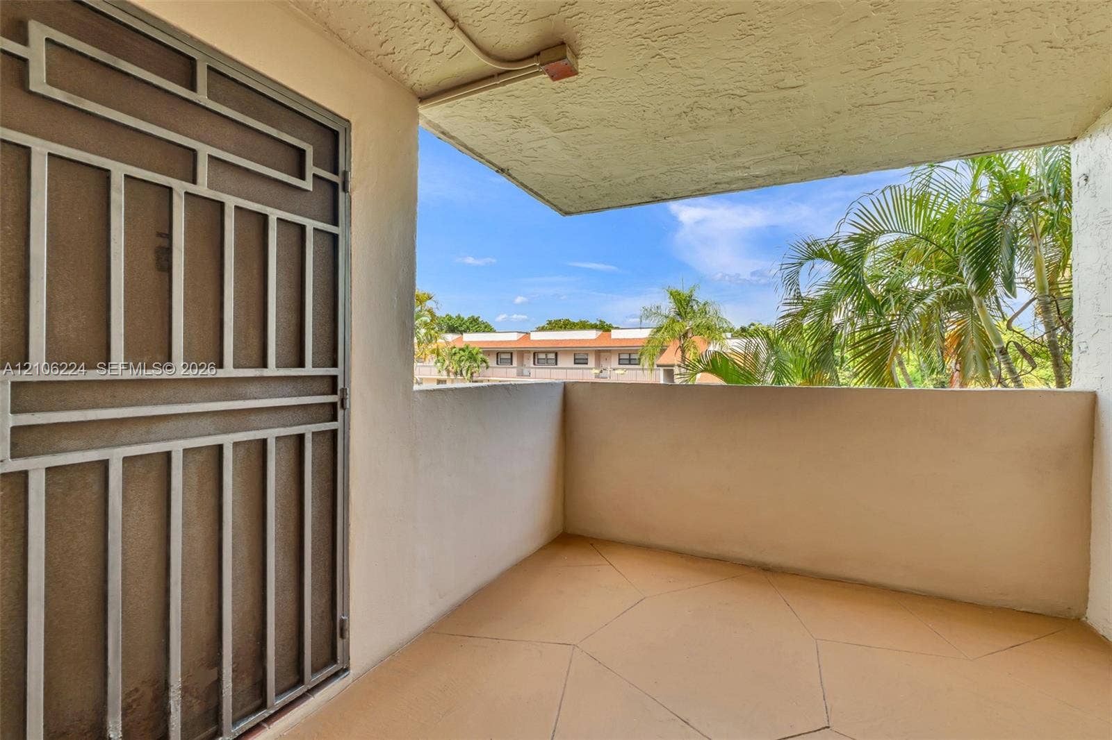 8887 Fontainebleau Boulevard, #206, Miami, Miami, FL 33172 Covered balcony featuring concrete flooring, a stucco ceiling, solid walls, and a metal security screen door
