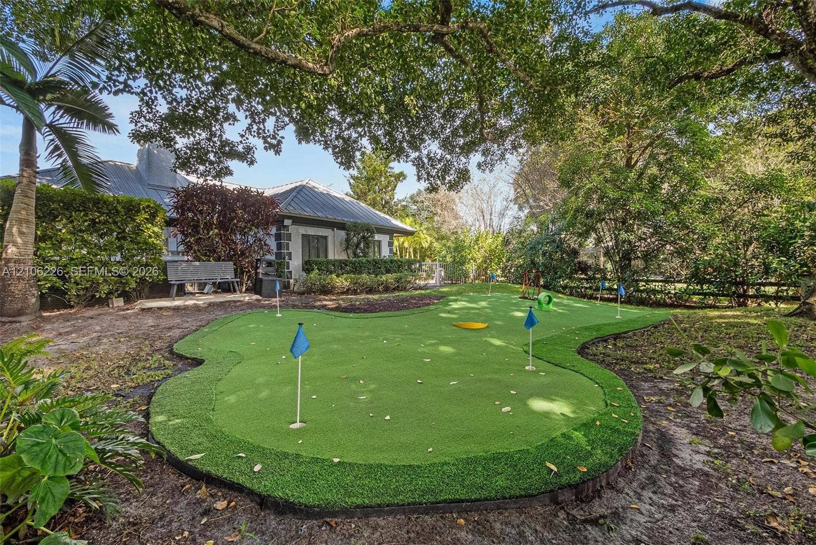 11155 SW 40th Street, Davie, FL 33328 Private backyard featuring an artificial turf putting green, mature trees, and landscaping