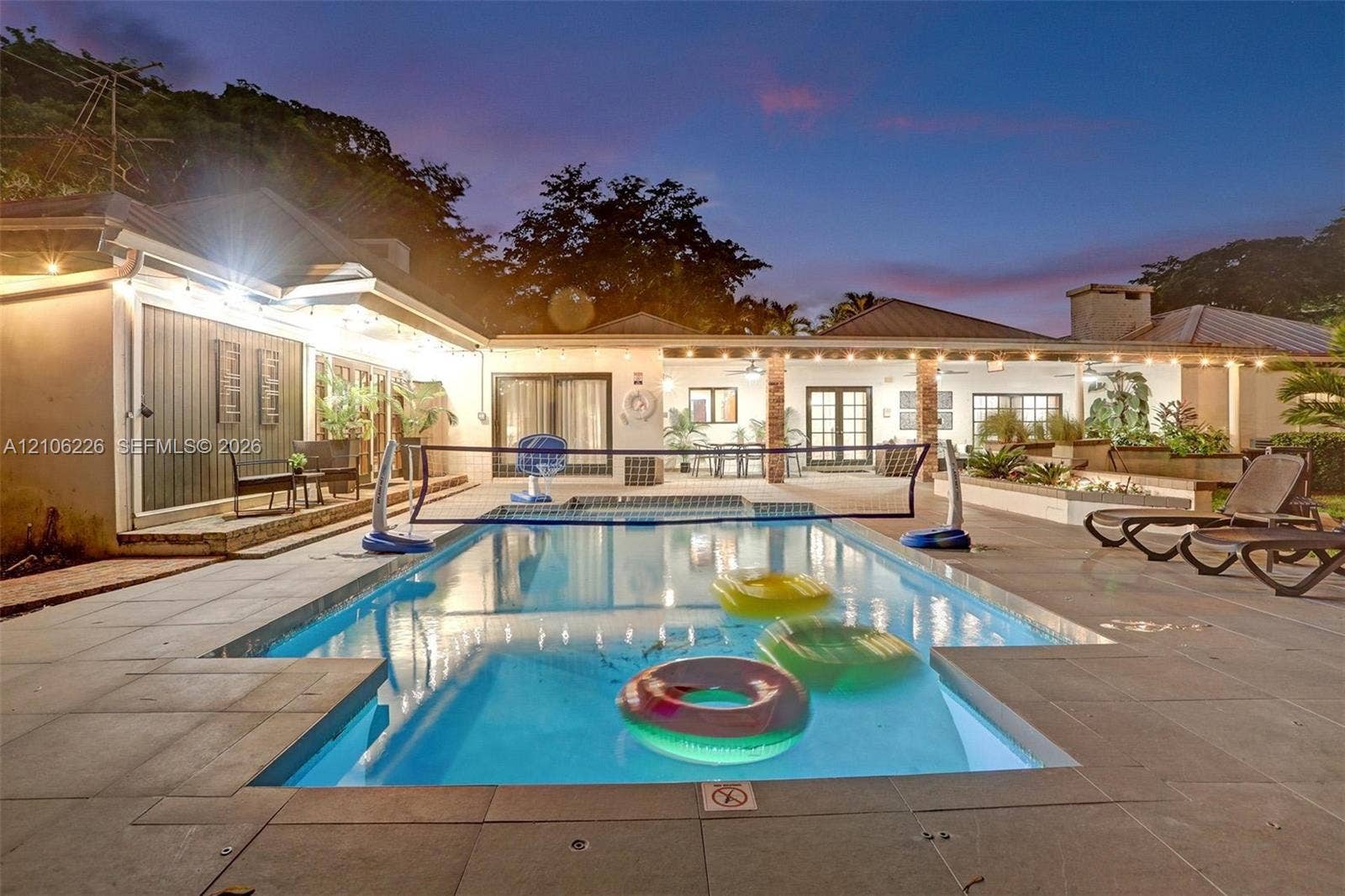 11155 SW 40th Street, Davie, FL 33328 Rectangular swimming pool with stone paver surround, covered patio, exterior masonry chimney, and recessed ceiling lighting