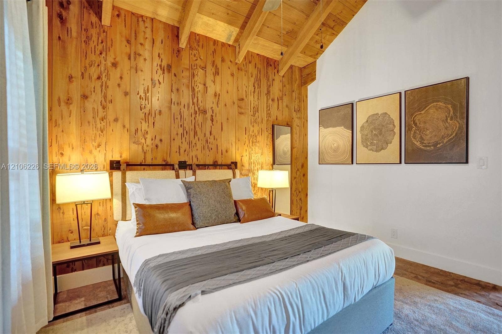 11155 SW 40th Street, Davie, FL 33328 Vaulted ceiling with exposed wood beams, vertical wood-paneled accent wall, and wood-finish flooring