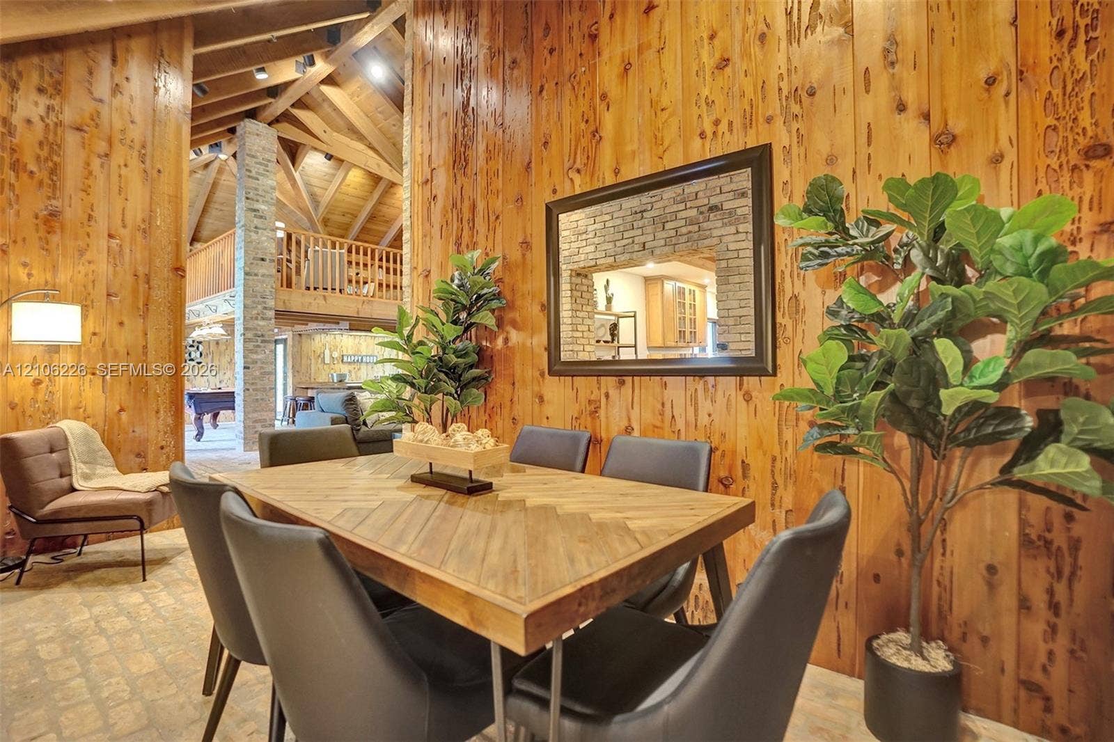 11155 SW 40th Street, Davie, FL 33328 Wood-paneled walls, vaulted ceiling with exposed timber beams, brick column feature, and light stone-finish flooring