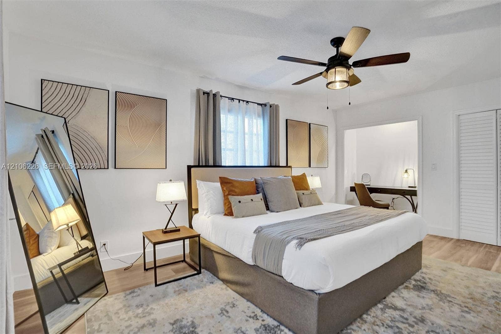 11155 SW 40th Street, Davie, FL 33328 Bedroom featuring wood-finish flooring, multi-pane window, ceiling fan with integrated light fixture, and louvered closet doors