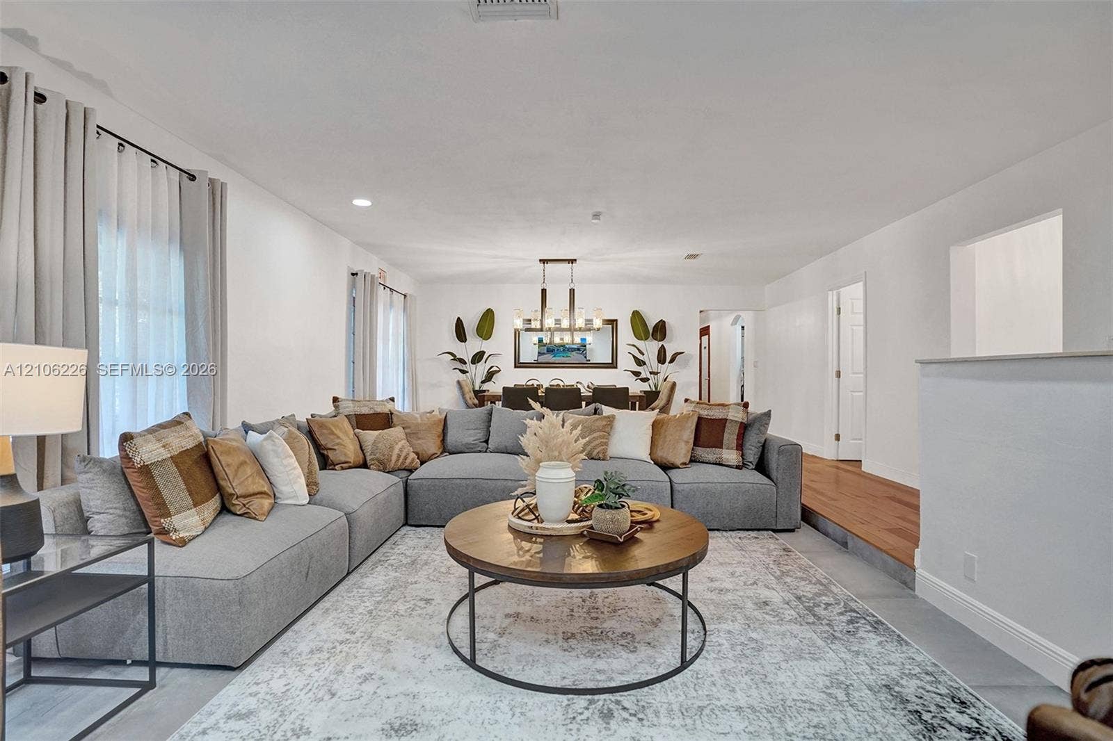 11155 SW 40th Street, Davie, FL 33328 Open-concept interior featuring recessed lighting, a modern multi-light chandelier, and wood-finish flooring