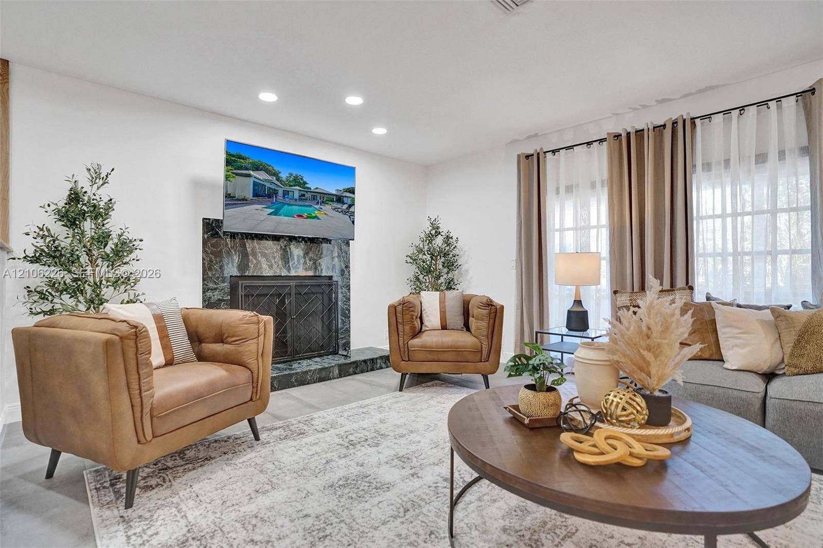 11155 SW 40th Street, Davie, FL 33328 Fireplace featuring a full-height stone surround, recessed ceiling lighting, and large windows with multi-pane detailing