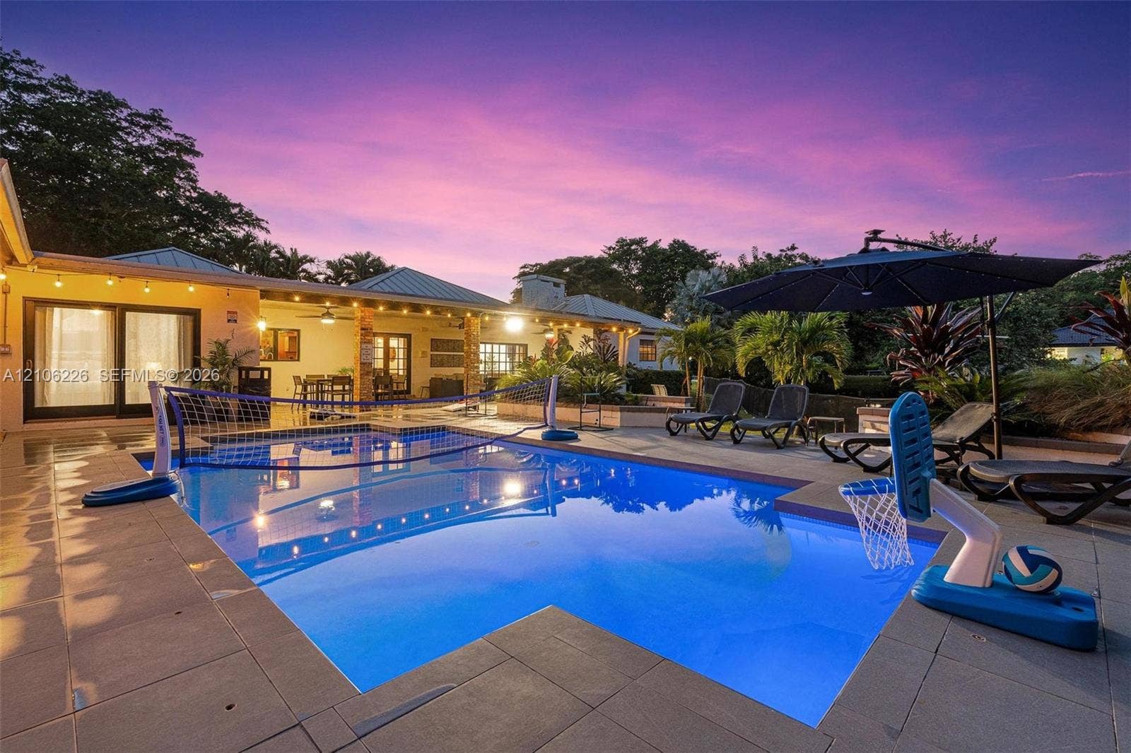 11155 SW 40th Street, Davie, FL 33328 In-ground swimming pool with stone-tiled decking and covered patio area