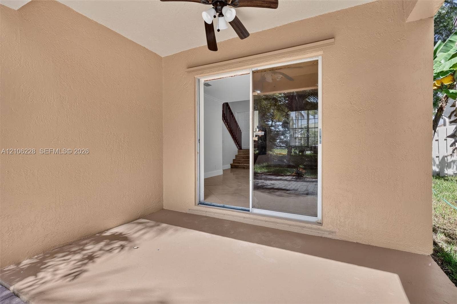 10760 SW 11th Drive, Davie, FL 33324 Covered patio featuring a painted concrete floor, stucco walls, and a ceiling-mounted fan with light fixture