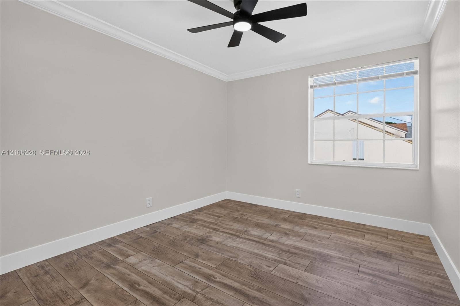 10760 SW 11th Drive, Davie, FL 33324 Interior space featuring wood-finish flooring, neutral wall paint, crown molding, multi-pane window, and a matte black ceiling fan