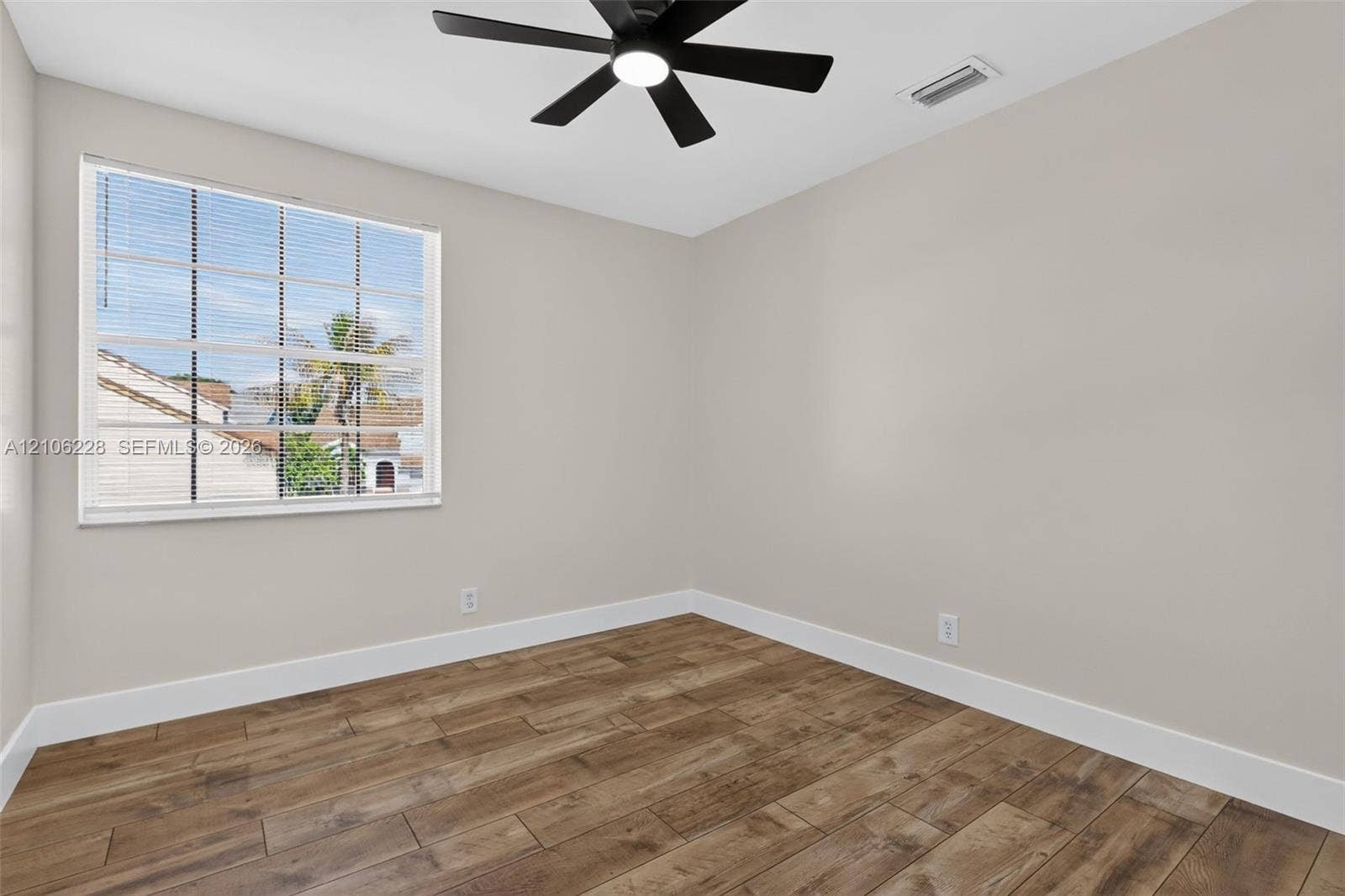 10760 SW 11th Drive, Davie, FL 33324 Neutral-toned walls, wood-finish flooring, and a ceiling-mounted fan with integrated light