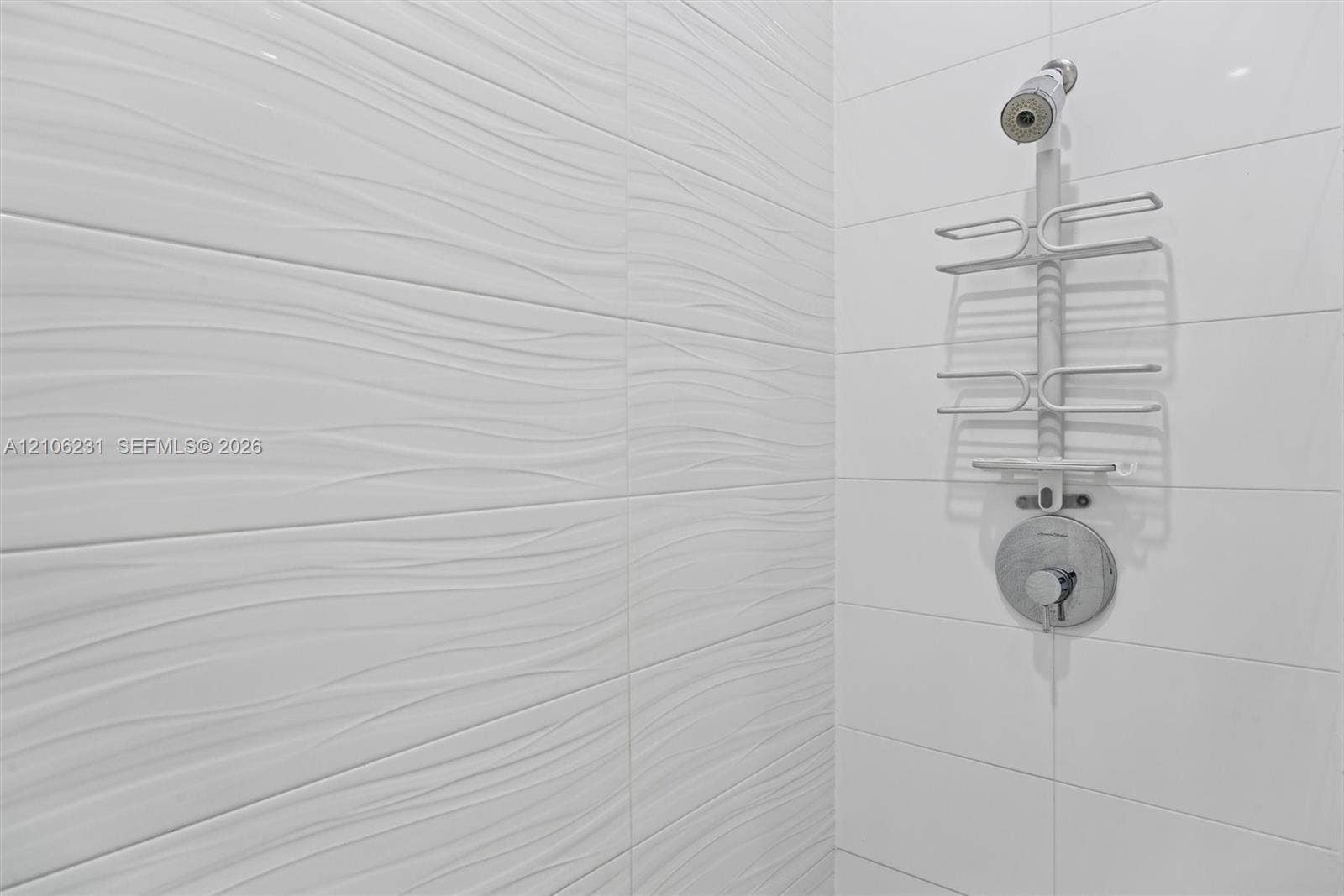 7875 NW 107th Avenue, #802, Doral, FL 33178 Textured white wall tiles with a wave-pattern finish, complemented by smooth white rectangular tiles.