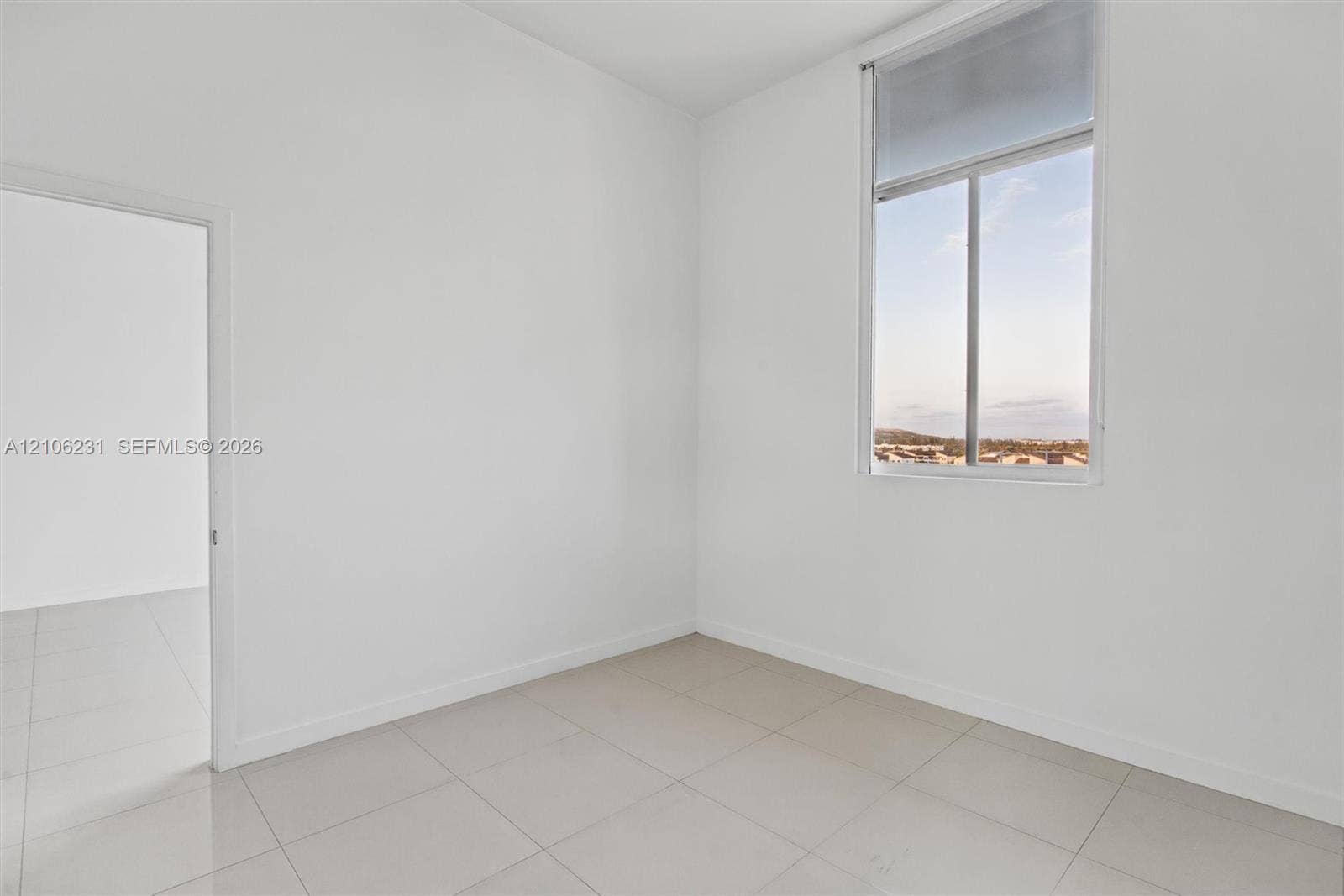 7875 NW 107th Avenue, #802, Doral, FL 33178 Bedroom with high ceilings, oversized window with exterior scenery, neutral walls, and 24x24 tile flooring