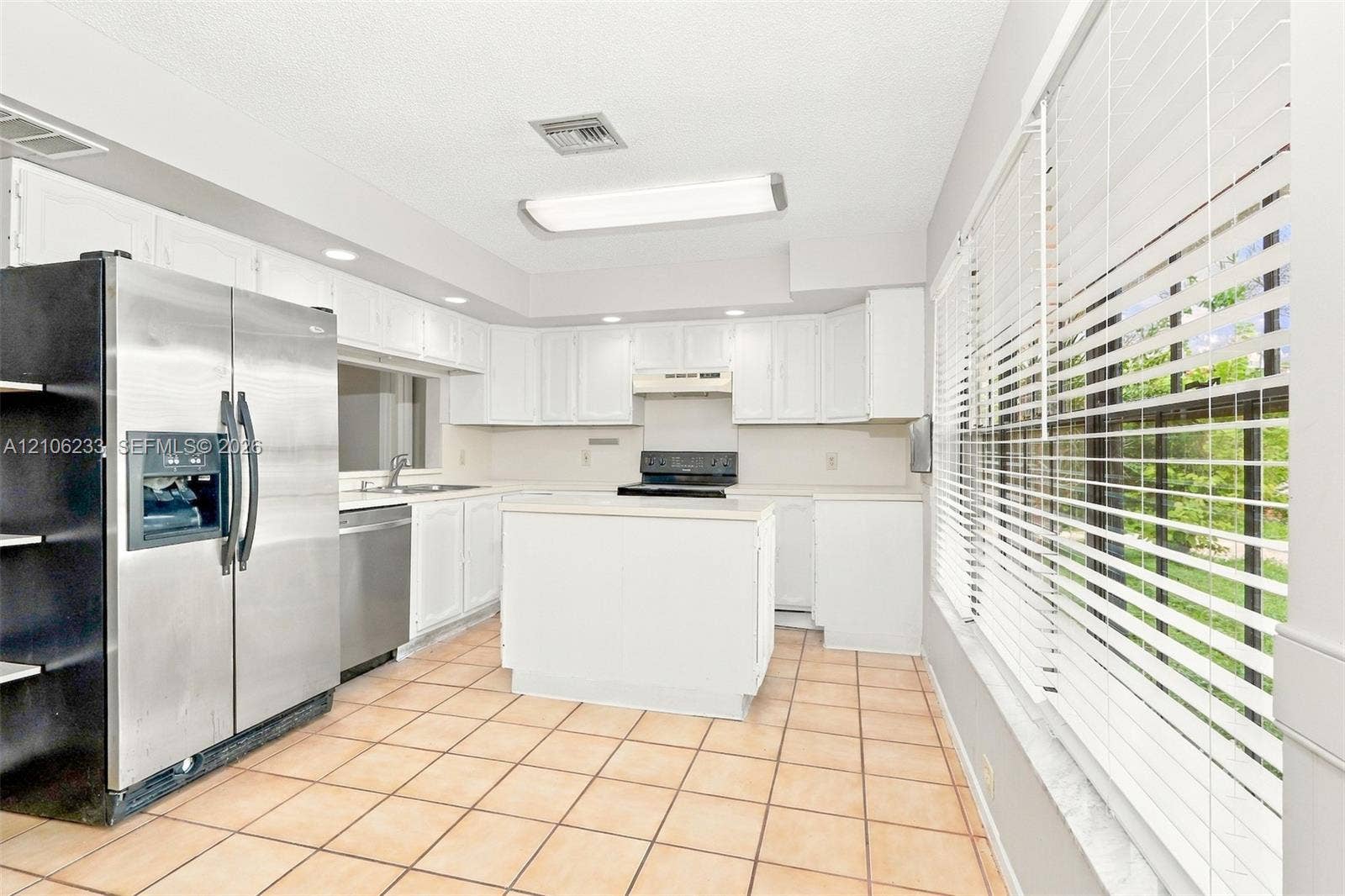 132 Santander Court, Royal Palm Beach, Royal Palm Beach, FL 33411 Kitchen featuring white cabinetry, central island, stainless steel refrigerator and dishwasher, and tile flooring