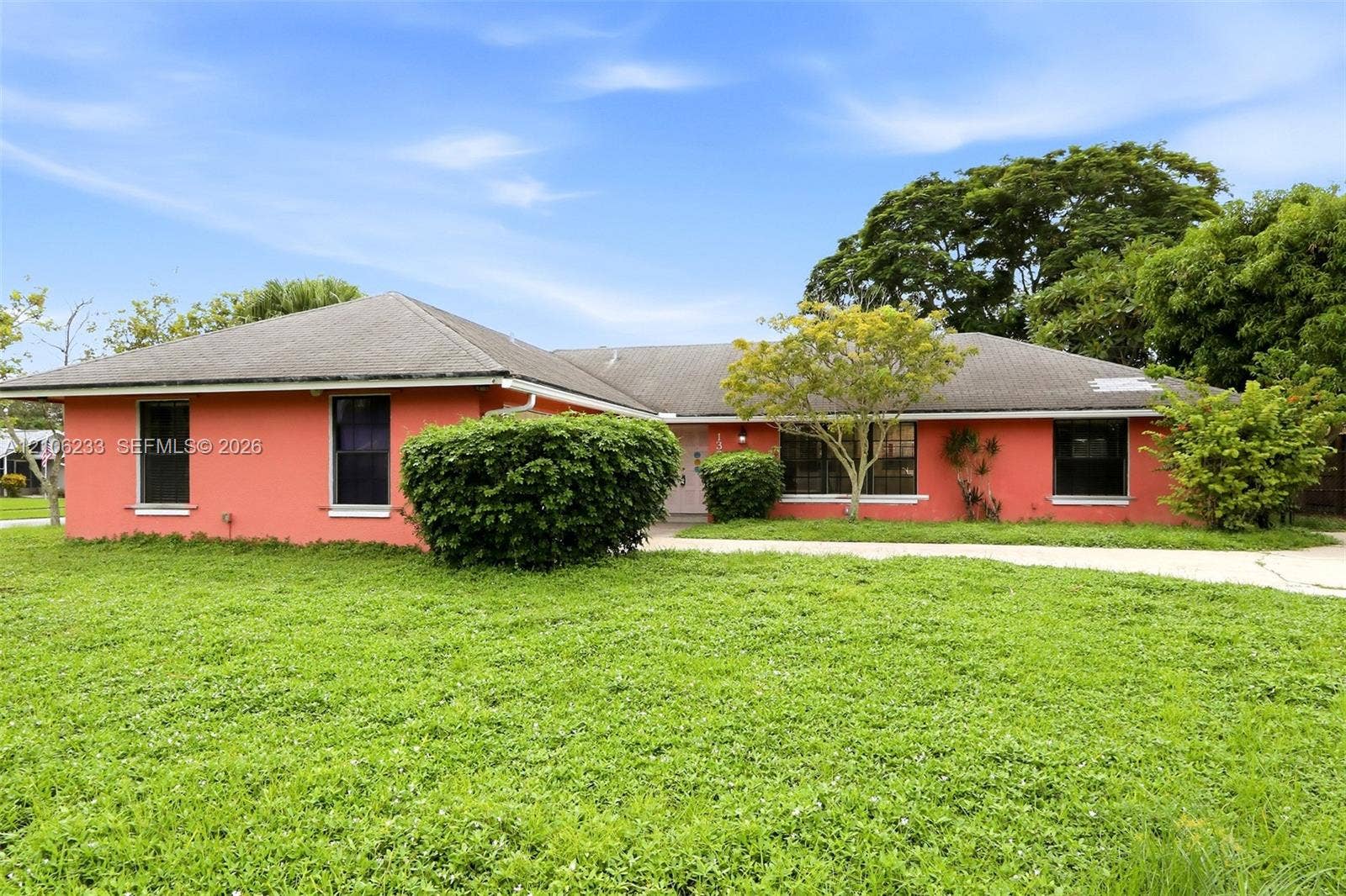 132 Santander Court, Royal Palm Beach, Royal Palm Beach, FL 33411 Single-story ranch-style residence featuring a stucco exterior, multi-hipped shingle roof, and expansive front yard