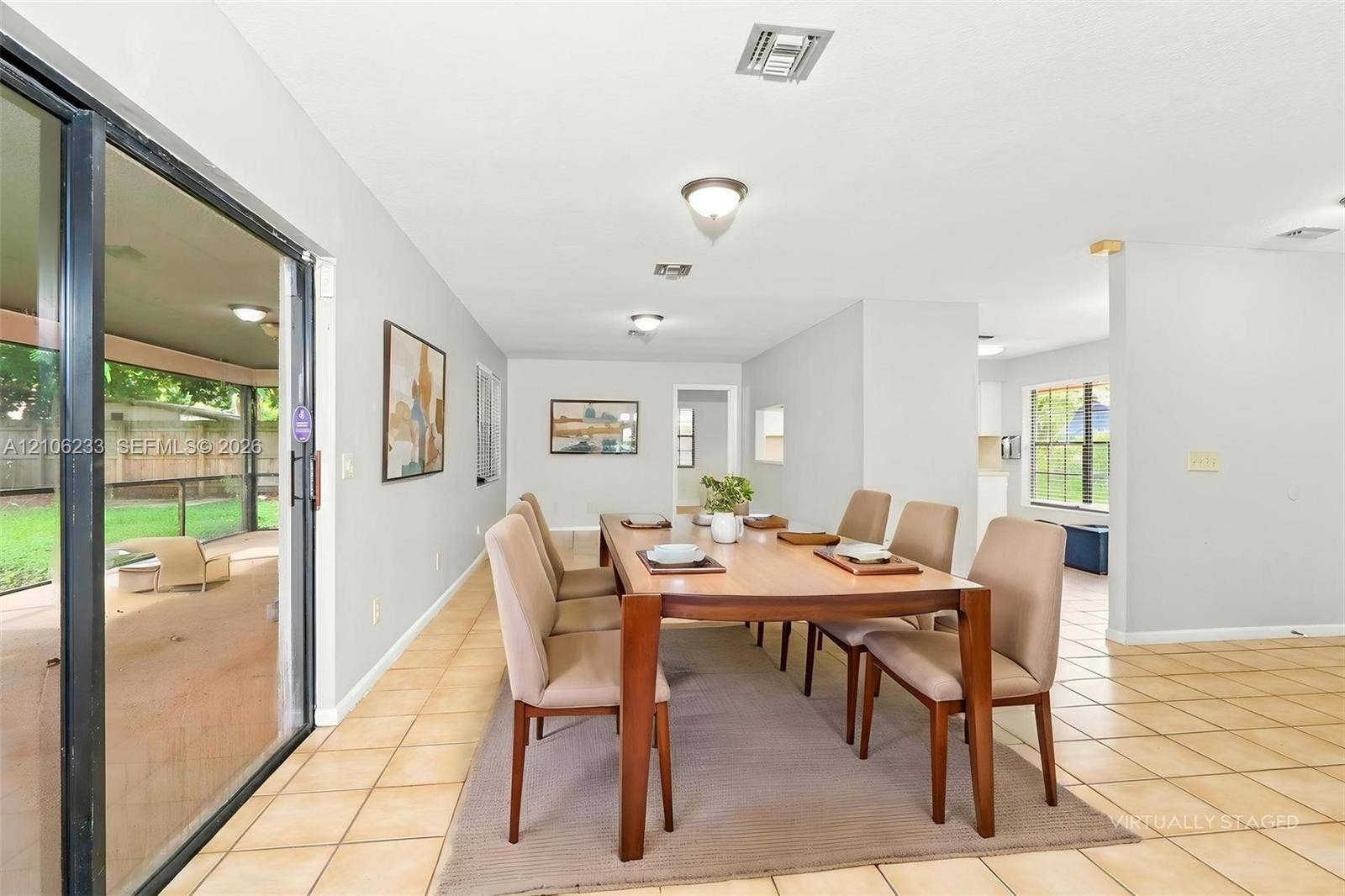 132 Santander Court, Royal Palm Beach, Royal Palm Beach, FL 33411 Spacious dining area featuring neutral tile flooring, recessed lighting, and a large sliding glass door providing access to a screened-in patio