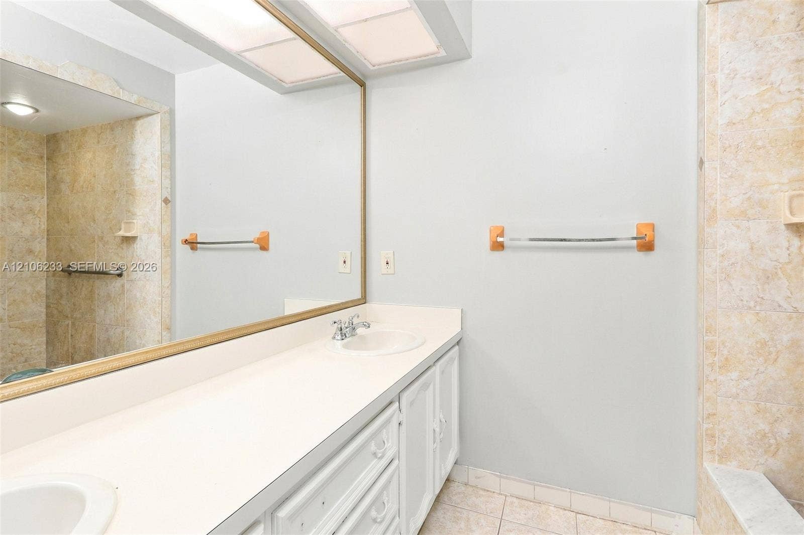 132 Santander Court, Royal Palm Beach, Royal Palm Beach, FL 33411 Bathroom vanity featuring a solid surface countertop, dual integrated sinks, and a large framed mirror with built-in overhead recessed lighting