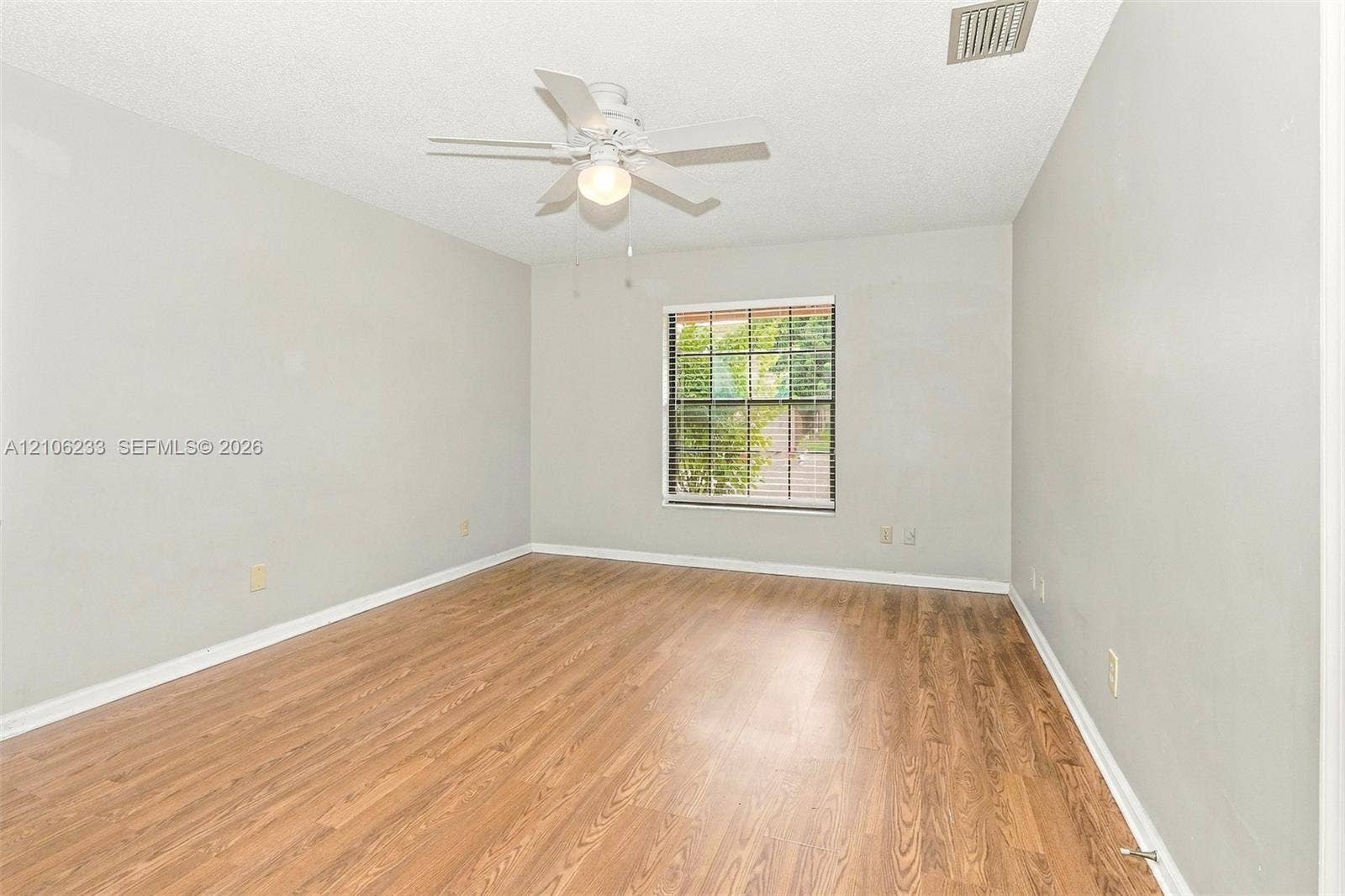 132 Santander Court, Royal Palm Beach, Royal Palm Beach, FL 33411 Interior space featuring wood-finish flooring, a multi-pane window, and a central ceiling fan with an integrated light fixture