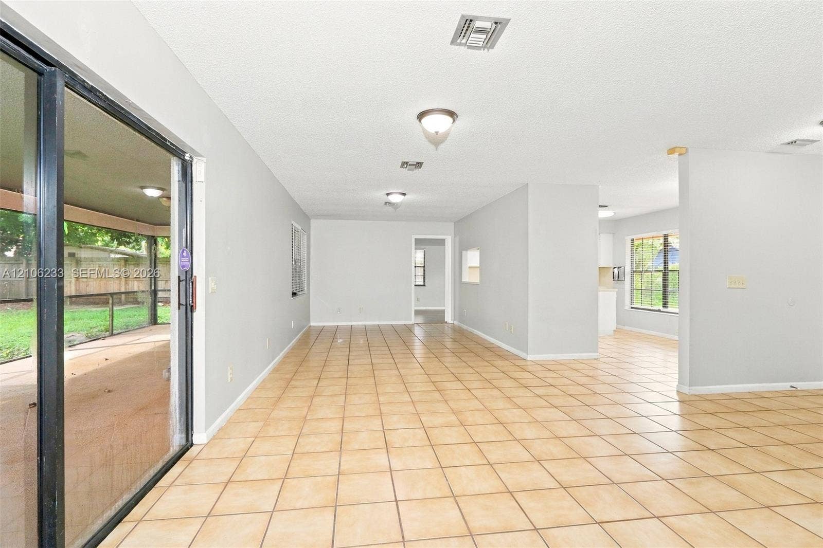 132 Santander Court, Royal Palm Beach, Royal Palm Beach, FL 33411 Open-concept interior featuring neutral wall tones, large-format ceramic tile flooring, recessed and flush-mount lighting, and expansive sliding glass doors
