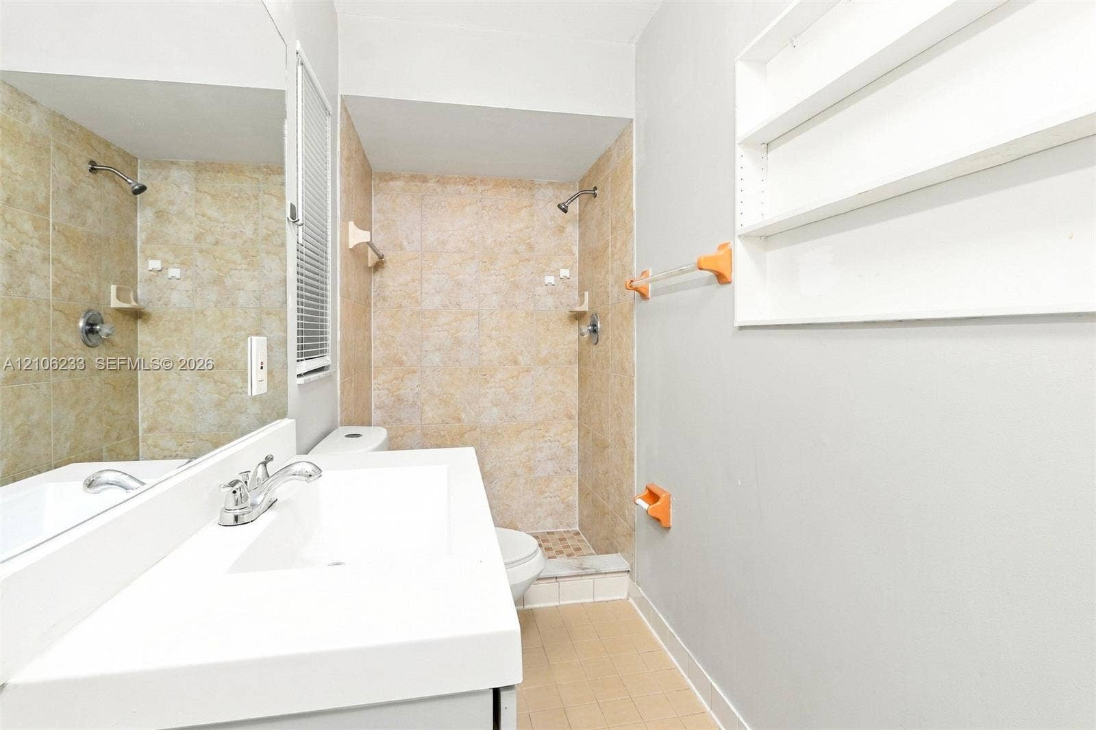 132 Santander Court, Royal Palm Beach, Royal Palm Beach, FL 33411 Bathroom featuring a vanity with an integrated rectangular sink, wall-to-wall mirror, tiled walk-in shower, built-in wall shelving, and tile flooring
